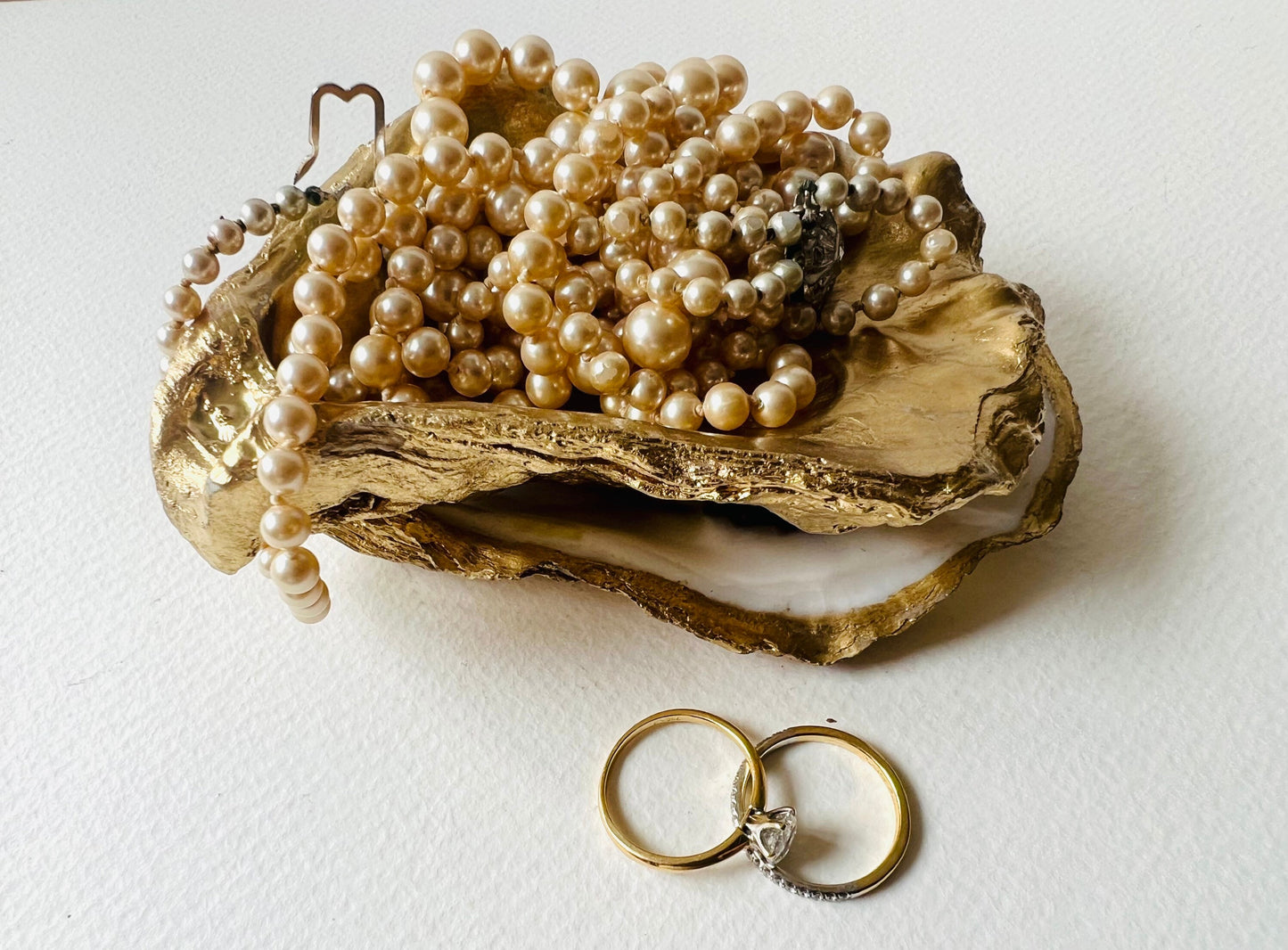 Gold leaf oyster shell jewellery dish with pearl finish, handmade Dorset oyster shell ring holder and trinket dish. Matching flat oyster base with gilded edges, eco-friendly coastal home decor. Unique oyster shell gift, wedding ring box, anniversary present, salt pinch pot, nautical bathroom accessory. Handcrafted shell ornament, sustainable oyster decor, handmade UK jewellery storage.