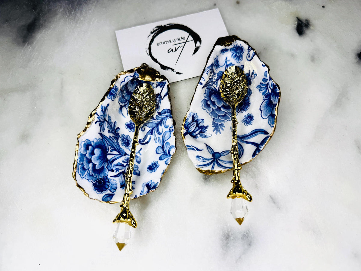 Pair of handmade Delft Blue oyster shell salt cellar set with blue and white floral pattern, gold leaf edging and matching gold crystal spoons. Coastal oyster shell pinch pots finished in glossy resin for elegant table decor