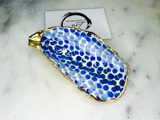 Handmade Emma Bridgewater Blue Dots oyster shell trinket dish, shown as a single jewellery tray with a blue and white dot pattern and hand-gilded gold leaf edges. Crafted from a natural Dorset oyster shell and sealed with glossy, crystal-clear resin. Coastal-inspired home decor, perfect for holding rings, earrings and small keepsakes, with each shell one of a kind and finished by hand.