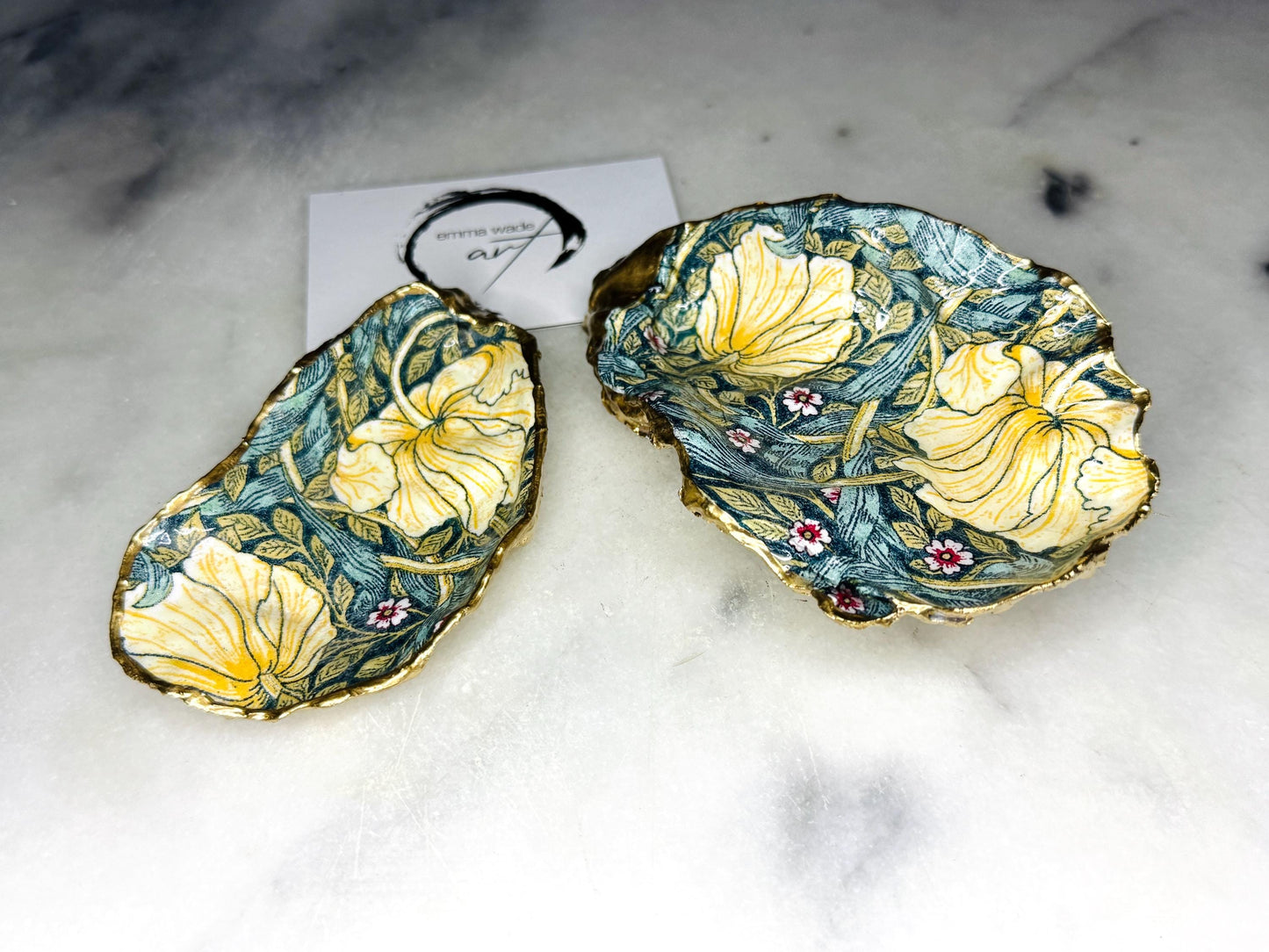 William Morris Golden Green Pimpernel oyster shell ring dish with gold leaf edge. A unique shell ring holder, ring tray, and jewellery organiser for rings, earrings, or cufflinks. Each shell features an art inspired floral design and is individually handmade from Dorset shells. Perfect as a trinket dish for bedside or dressing table storage. A thoughtful gift for weddings, anniversaries, birthdays, bridesmaids, or Christmas. A sustainable decorative keepsake for any jewellery lover.
