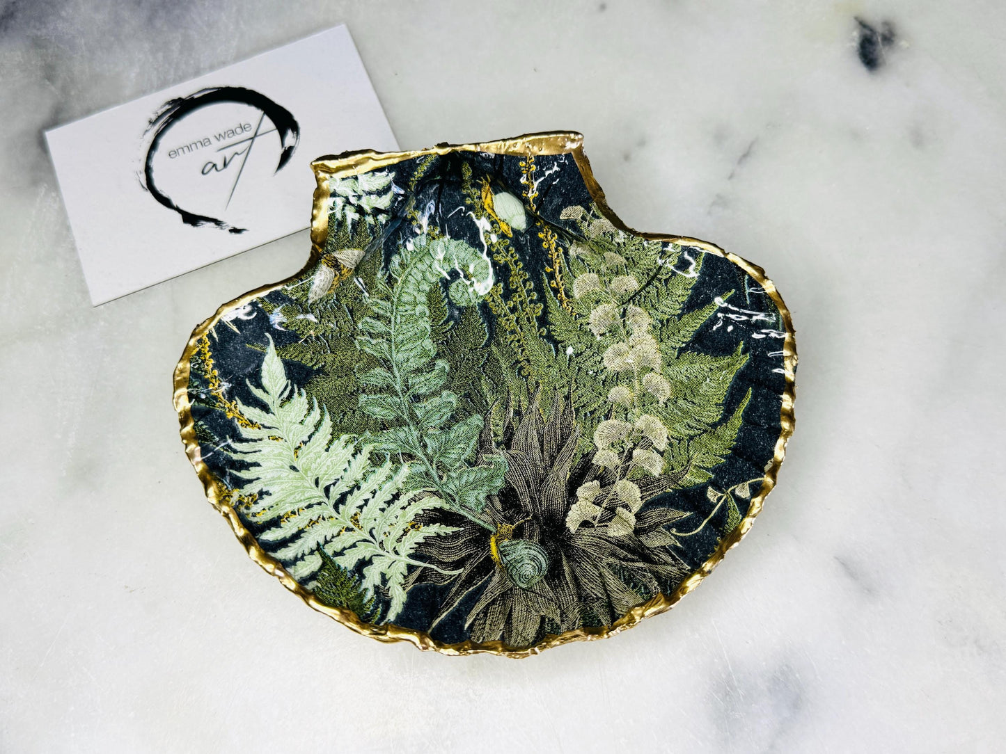 Handmade fern green scallop shell trinket dish with botanical forest fern design, gold leaf edging, and glossy resin finish. Natural Dorset shell jewellery dish inspired by woodland décor and cottagecore interiors, styled as a ring holder, trinket tray, or coastal nature-inspired gift.