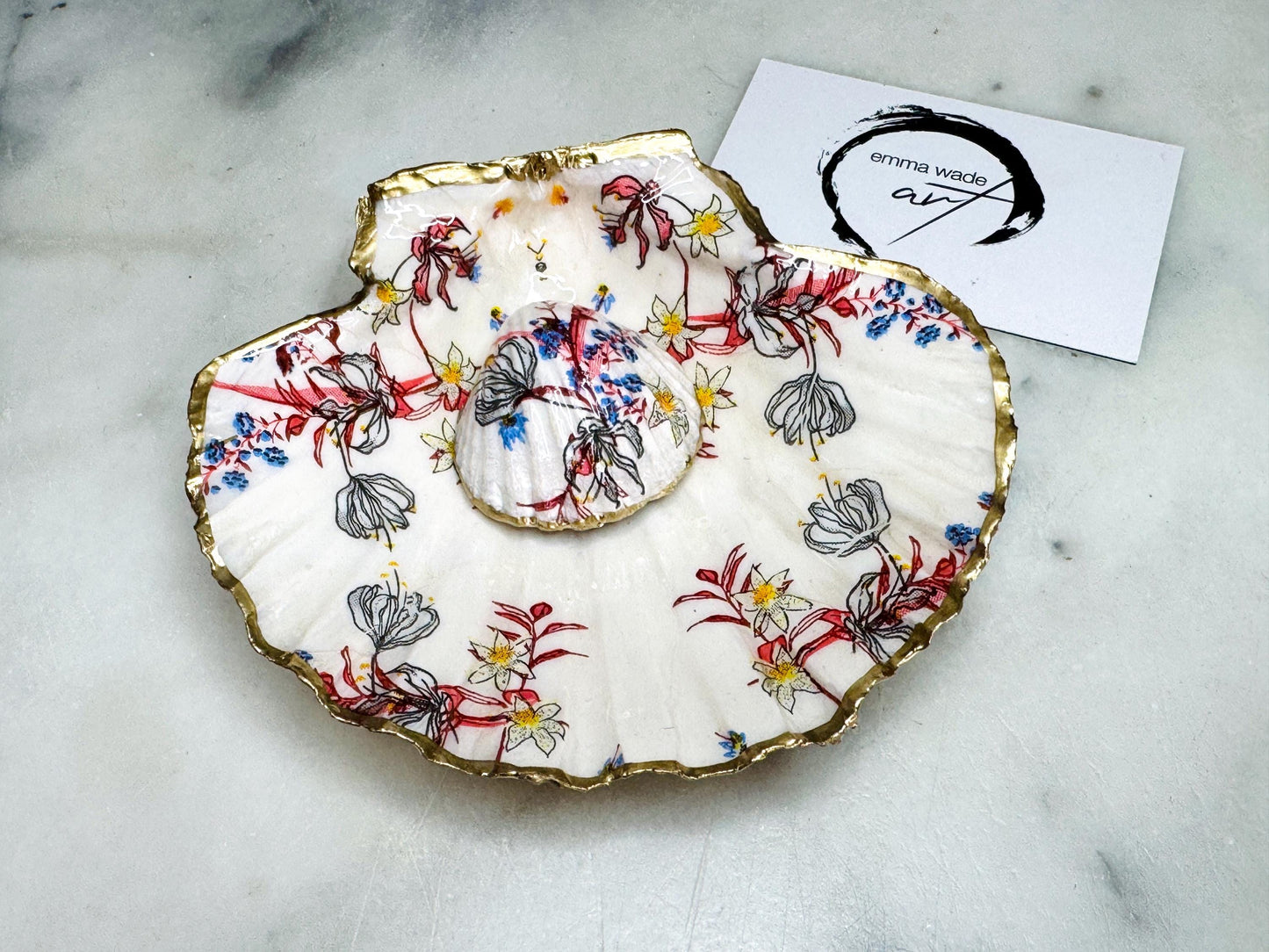Handcrafted Dorset shell dish set featuring red and blue floral designs on scallop and cockle shells | Cockle shell includes a Swarovski pearl ring rest to prevent rings from sliding | Gilded with liquid gold leaf and sealed with glossy resin | Perfect as a jewellery or ring holder, trinket tray, or coastal gift | Each shell is sustainably sourced and hand finished in the UK | Ideal wedding or anniversary keepsake