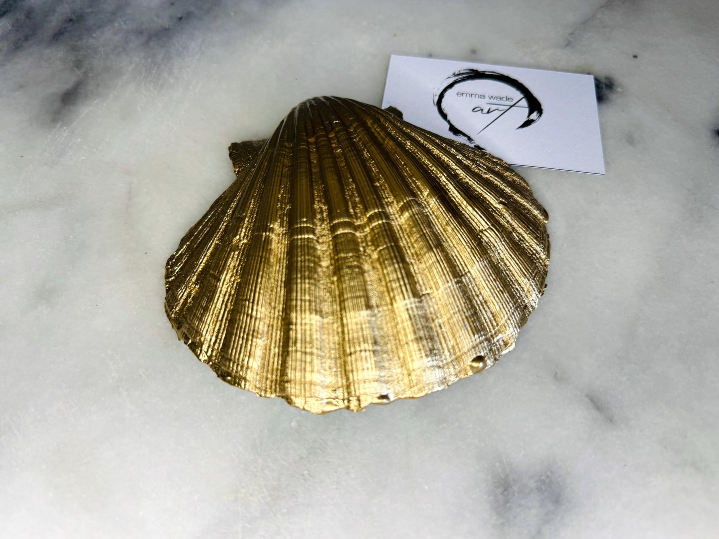 Handcrafted Dorset scallop shell trinket dish with blue spring flower design, finished with a gold leaf rim and glossy resin. The shell shows delicate blue floral motifs with green stems on a natural shell, styled on a light background. A coastal inspired jewellery or ring holder, perfect as a decorative keepsake dish, bathroom accent, or thoughtful handmade gift.