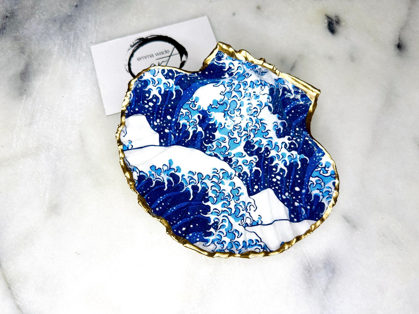 Great Wave of Kanagawa inspired scallop shell trinket dish with deep blue ocean wave artwork, gold leaf edging and glossy resin finish. Handmade coastal jewellery tray and Japanese ocean-inspired ring dish created from a natural Dorset scallop shell.