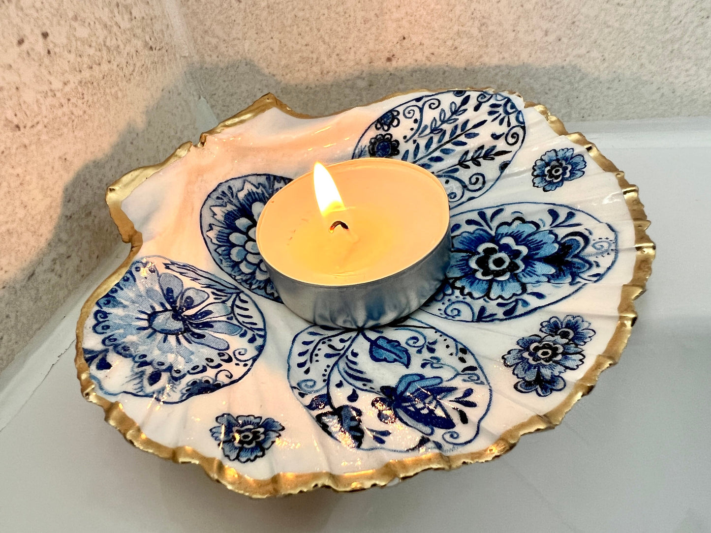 Handmade Dorset scallop shell trinket dishes featuring vintage inspired blue and white egg artwork with hand-painted gold leaf edging and glossy crystal clear resin. Elegant coastal jewellery dishes styled with Nordic and Scandinavian inspired porcelain patterns, photographed on soft neutral backgrounds with luxurious gilded detailing.