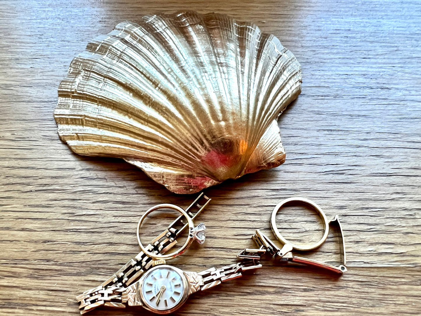 Handmade scallop shell trinket dish featuring a bumblebee illustration with gold leaf edging and glossy resin finish. Coastal jewellery dish in natural white shell with bee artwork, displayed as a ring holder and handmade bee lover gift