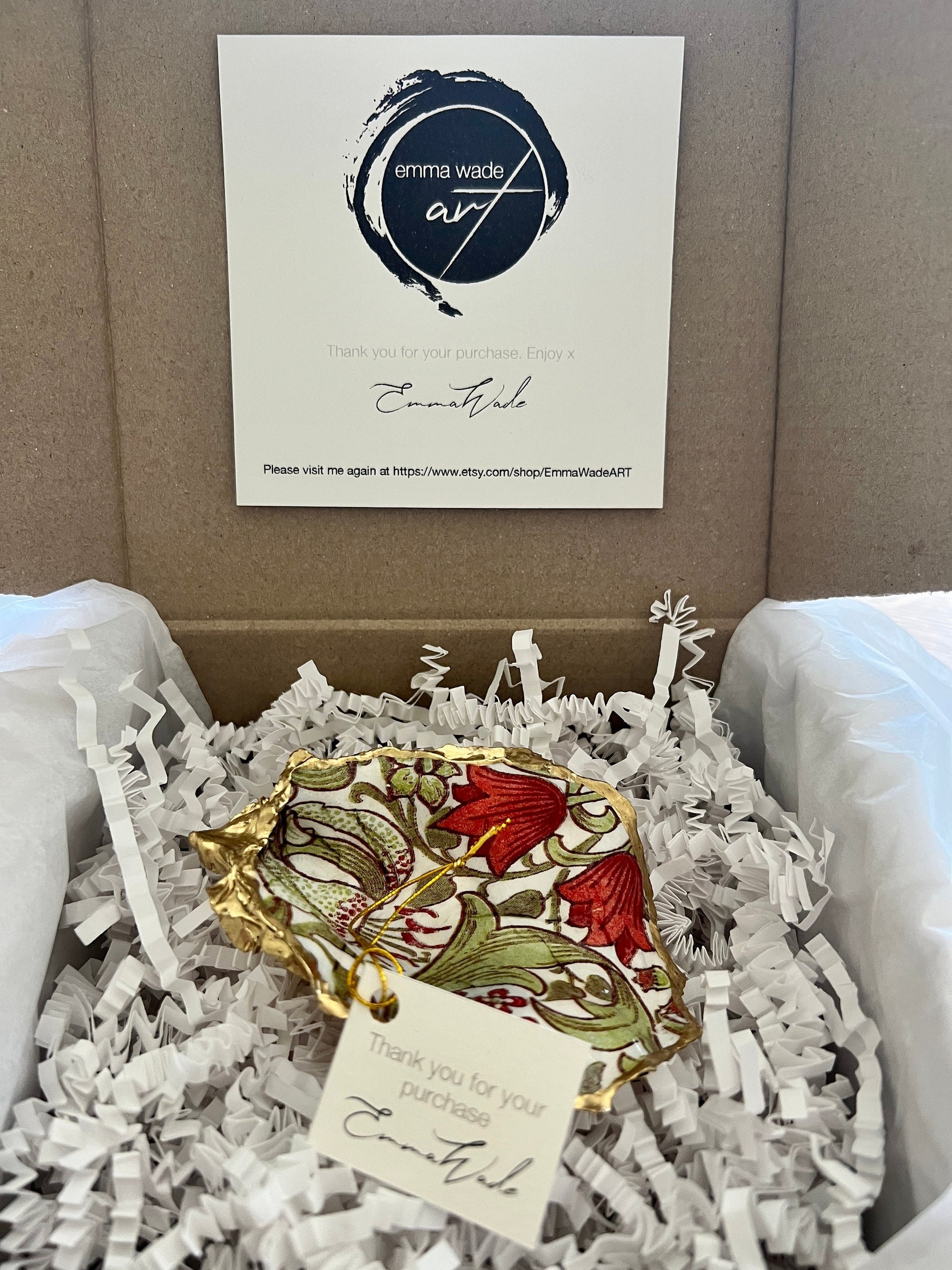 Handmade Dorset oyster shell ring dish featuring William Morris Golden Lily floral artwork in green, red and gold tones. Natural oyster shell trinket dish with pearlescent interior, hand-finished liquid gold leaf edging and glossy resin coating. Decorative jewellery holder and coastal heritage gift inspired by classic William Morris interiors and Arts and Crafts design.
