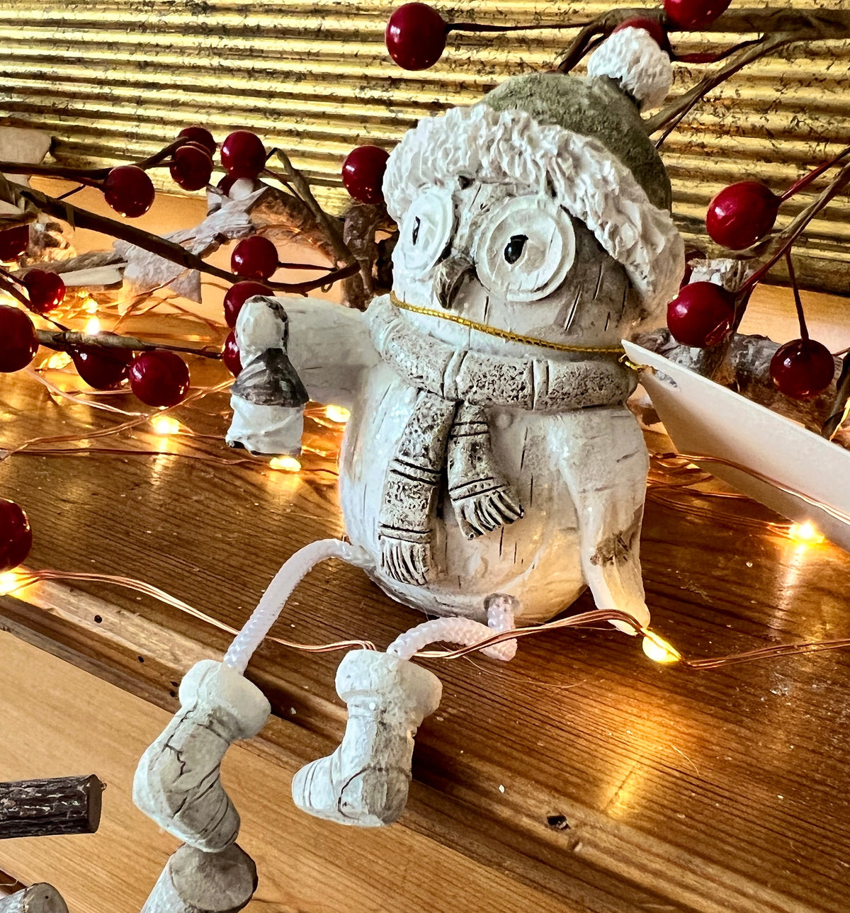 Set of three woodland Christmas owl shelf sitter decorations in soft white, grey and natural tones, featuring winter hats, scarves and festive details. Moulded resin owl ornaments with subtle glitter accents and dangling cord legs with little boots, designed to sit on a shelf, mantelpiece or windowsill. Festive woodland Christmas décor and owl lover gift.