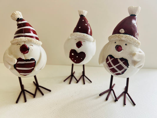 Set of three hand finished robin Christmas ornaments with festive hats, scarves and red heart details. Rustic woodland style bird decorations in cream, burgundy and red tones, perfect for Christmas tree décor, festive styling and stocking filler gifts.