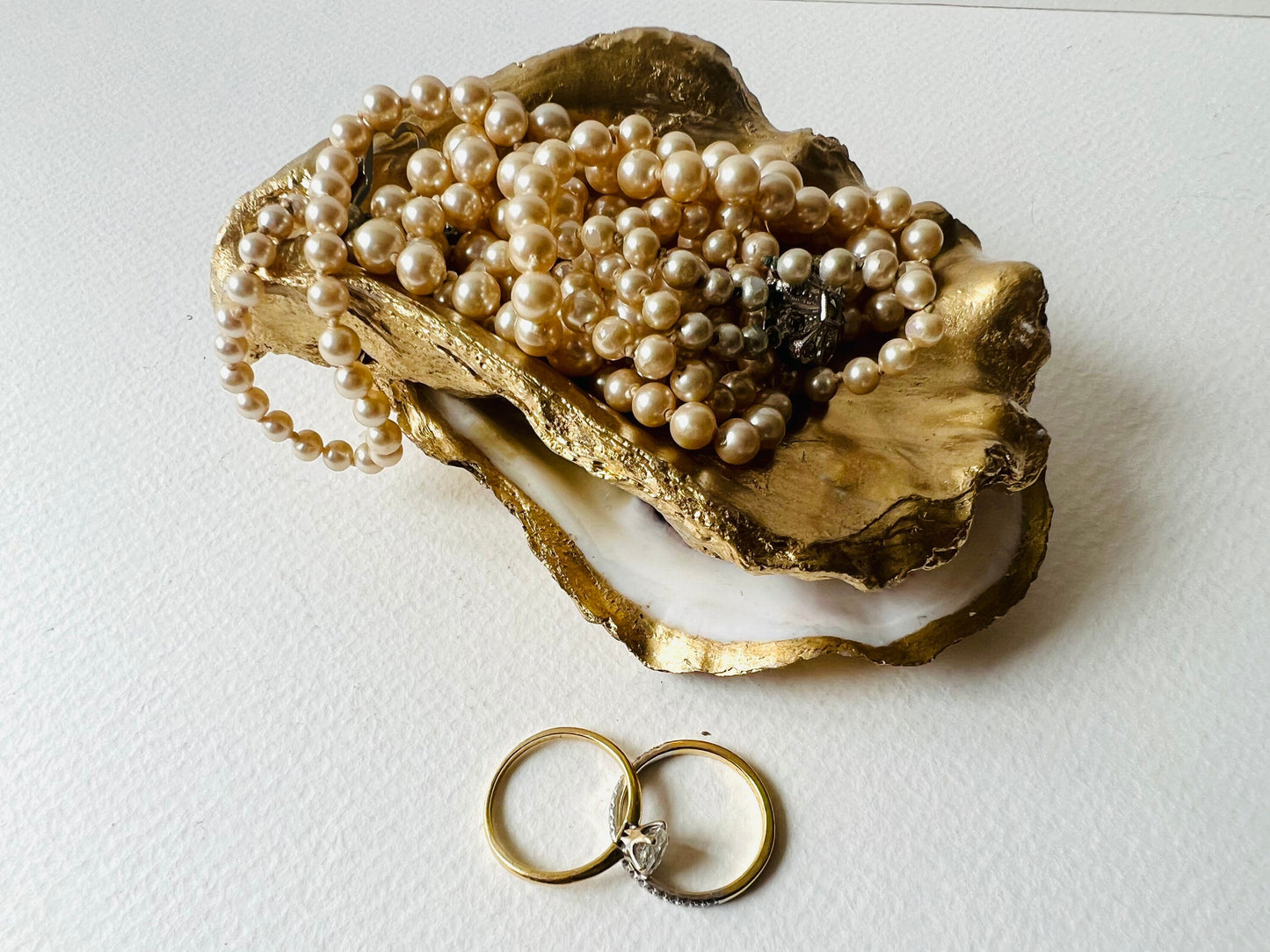 Gold leaf oyster shell jewellery dish with pearl finish, handmade Dorset oyster shell ring holder and trinket dish. Matching flat oyster base with gilded edges, eco-friendly coastal home decor. Unique oyster shell gift, wedding ring box, anniversary present, salt pinch pot, nautical bathroom accessory. Handcrafted shell ornament, sustainable oyster decor, handmade UK jewellery storage.