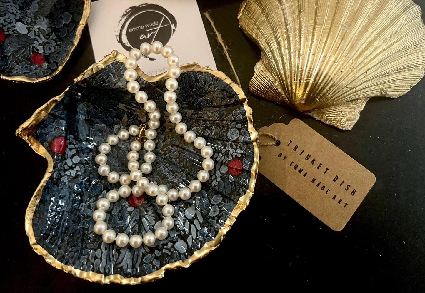 Handmade Marimekko inspired scallop shell trinket dish featuring bold Scandinavian floral design in deep blue with red accents. Natural Dorset scallop shell hand gilded with liquid gold leaf edging and sealed with glossy resin for a luxurious shine. Coastal home décor suitable as a jewellery dish, ring tray, trinket holder, wedding gift, bathroom décor or modern Nordic inspired shelf styling. Unique handcrafted shell décor inspired by botanical Scandinavian design.