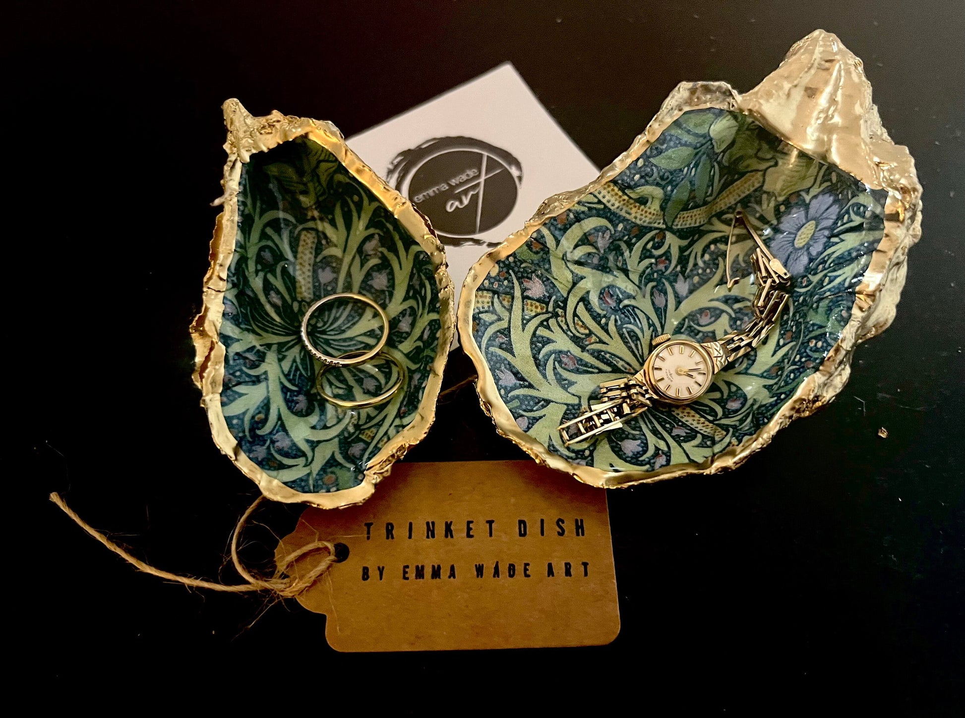 Handmade William Morris inspired oyster shell trinket dish in green and blue tones, finished with gold leaf and sealed with glossy resin. Coastal jewellery dish made from a Dorset oyster shell, featuring a seaweed decoupage design. Perfect for holding rings, earrings and small treasures. Decorative shell bowl photographed on a light background, showing the natural shell shape, detailed pattern and gilded edges.
