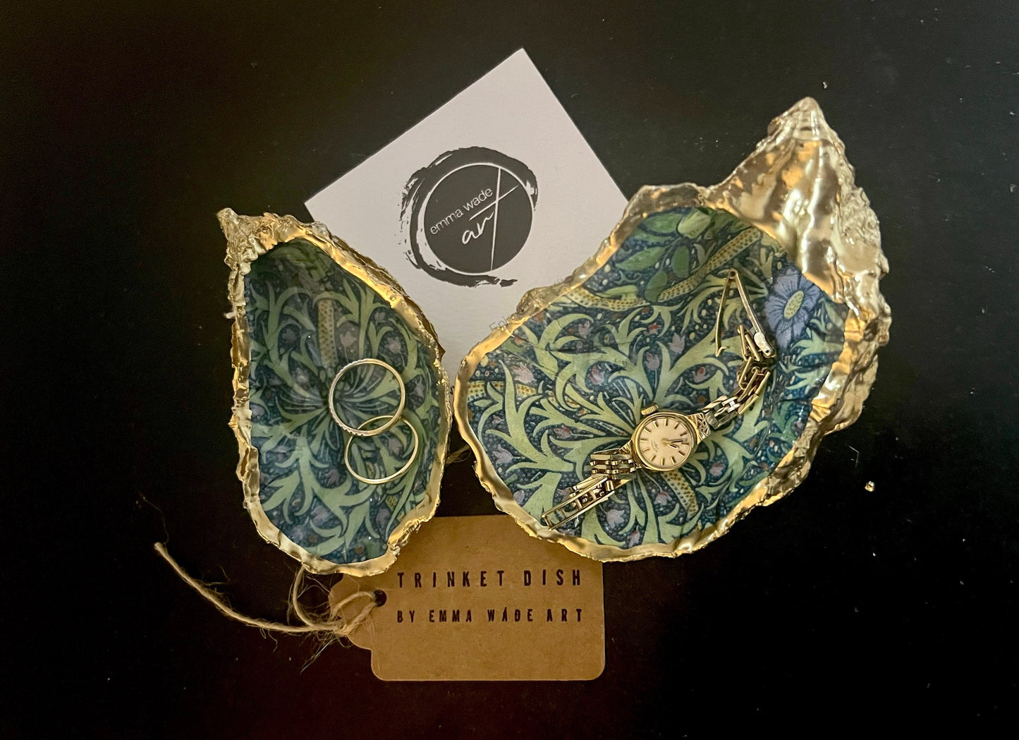 Handmade William Morris inspired oyster shell trinket dish in green and blue tones, finished with gold leaf and sealed with glossy resin. Coastal jewellery dish made from a Dorset oyster shell, featuring a seaweed decoupage design. Perfect for holding rings, earrings and small treasures. Decorative shell bowl photographed on a light background, showing the natural shell shape, detailed pattern and gilded edges.