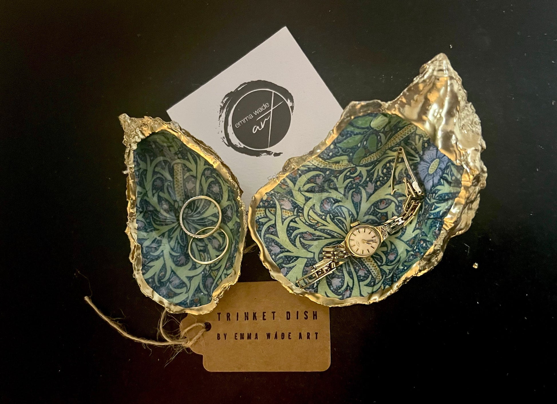 Handmade William Morris inspired oyster shell trinket dish in green and blue tones, finished with gold leaf and sealed with glossy resin. Coastal jewellery dish made from a Dorset oyster shell, featuring a seaweed decoupage design. Perfect for holding rings, earrings and small treasures. Decorative shell bowl photographed on a light background, showing the natural shell shape, detailed pattern and gilded edges.