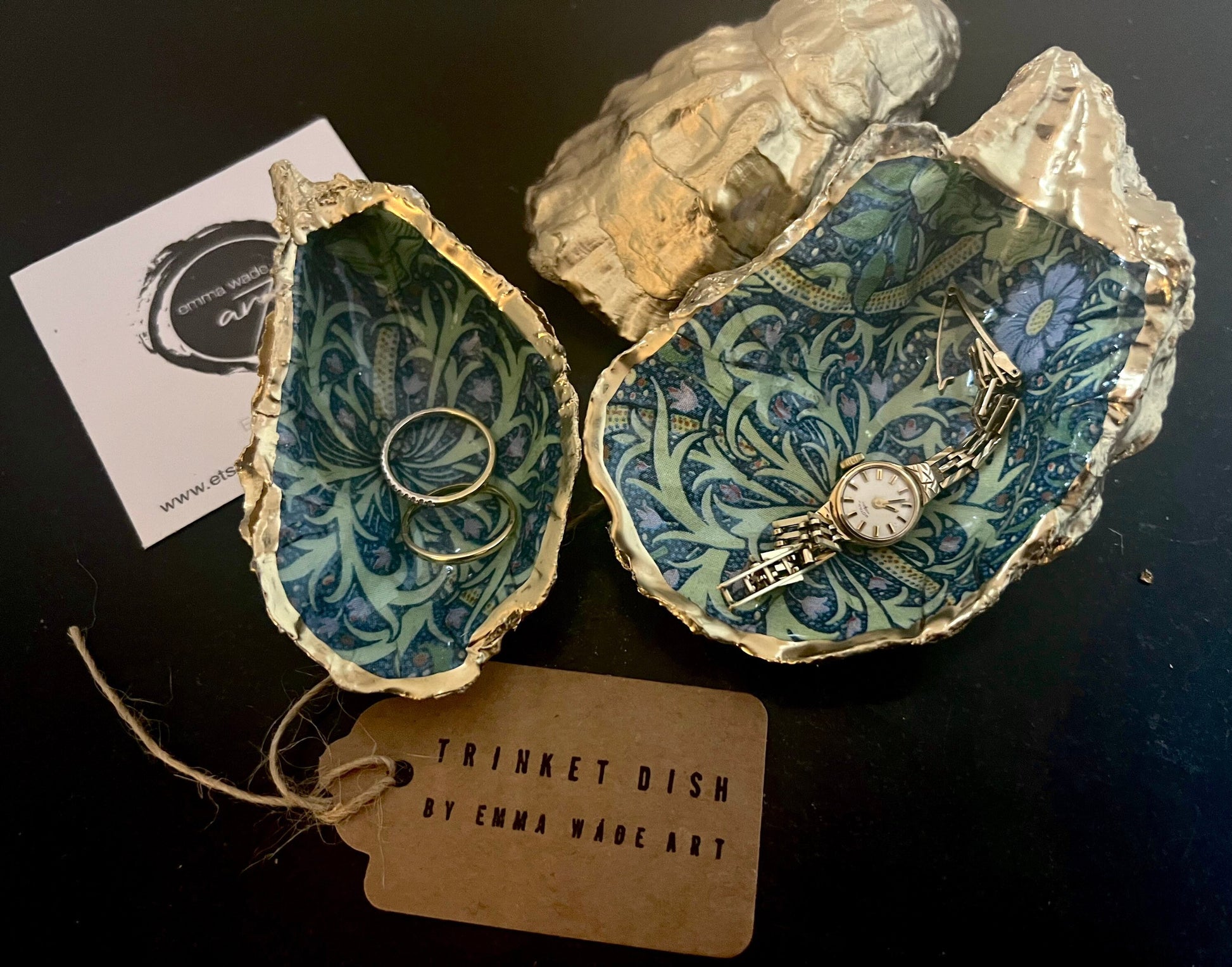 Handmade William Morris inspired oyster shell trinket dish in green and blue tones, finished with gold leaf and sealed with glossy resin. Coastal jewellery dish made from a Dorset oyster shell, featuring a seaweed decoupage design. Perfect for holding rings, earrings and small treasures. Decorative shell bowl photographed on a light background, showing the natural shell shape, detailed pattern and gilded edges.