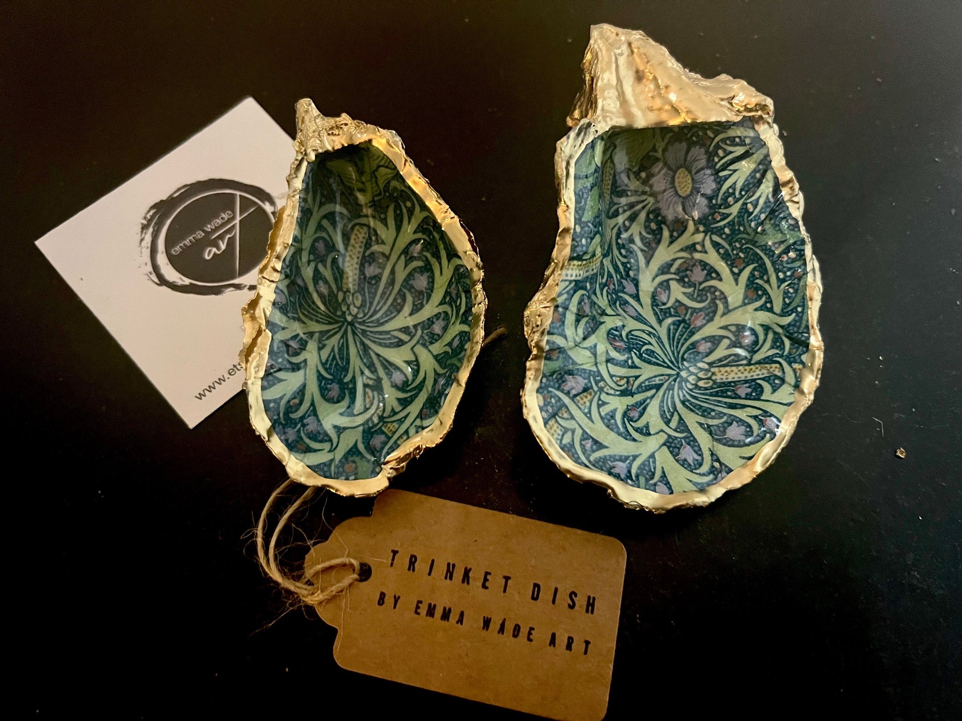 Handmade William Morris inspired oyster shell trinket dish in green and blue tones, finished with gold leaf and sealed with glossy resin. Coastal jewellery dish made from a Dorset oyster shell, featuring a seaweed decoupage design. Perfect for holding rings, earrings and small treasures. Decorative shell bowl photographed on a light background, showing the natural shell shape, detailed pattern and gilded edges.