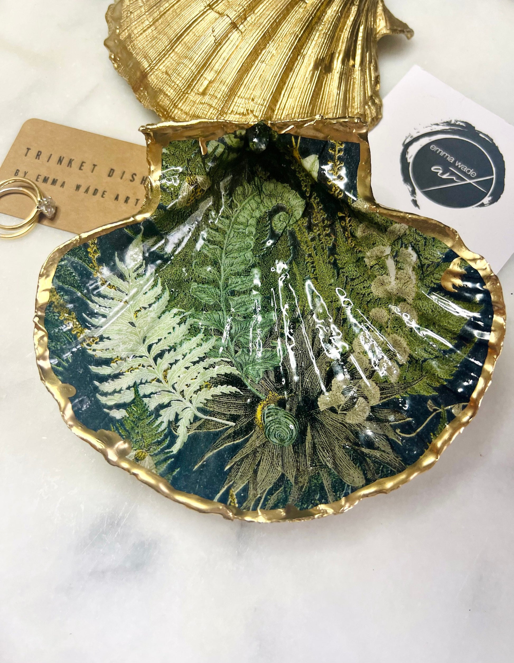 Handmade fern green scallop shell trinket dish with botanical forest fern design, gold leaf edging, and glossy resin finish. Natural Dorset shell jewellery dish inspired by woodland décor and cottagecore interiors, styled as a ring holder, trinket tray, or coastal nature-inspired gift.