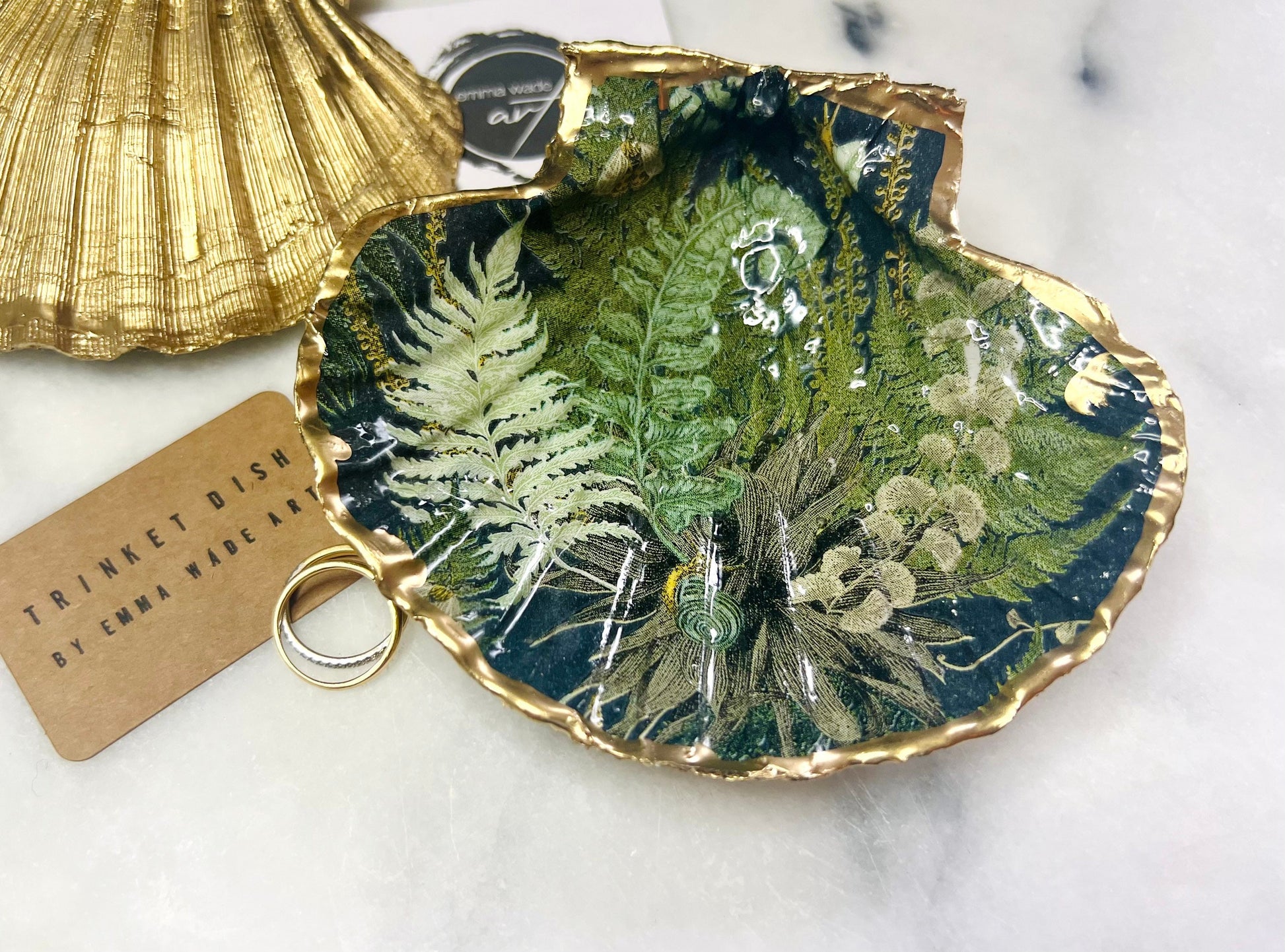 Handmade fern green scallop shell trinket dish with botanical forest fern design, gold leaf edging, and glossy resin finish. Natural Dorset shell jewellery dish inspired by woodland décor and cottagecore interiors, styled as a ring holder, trinket tray, or coastal nature-inspired gift.