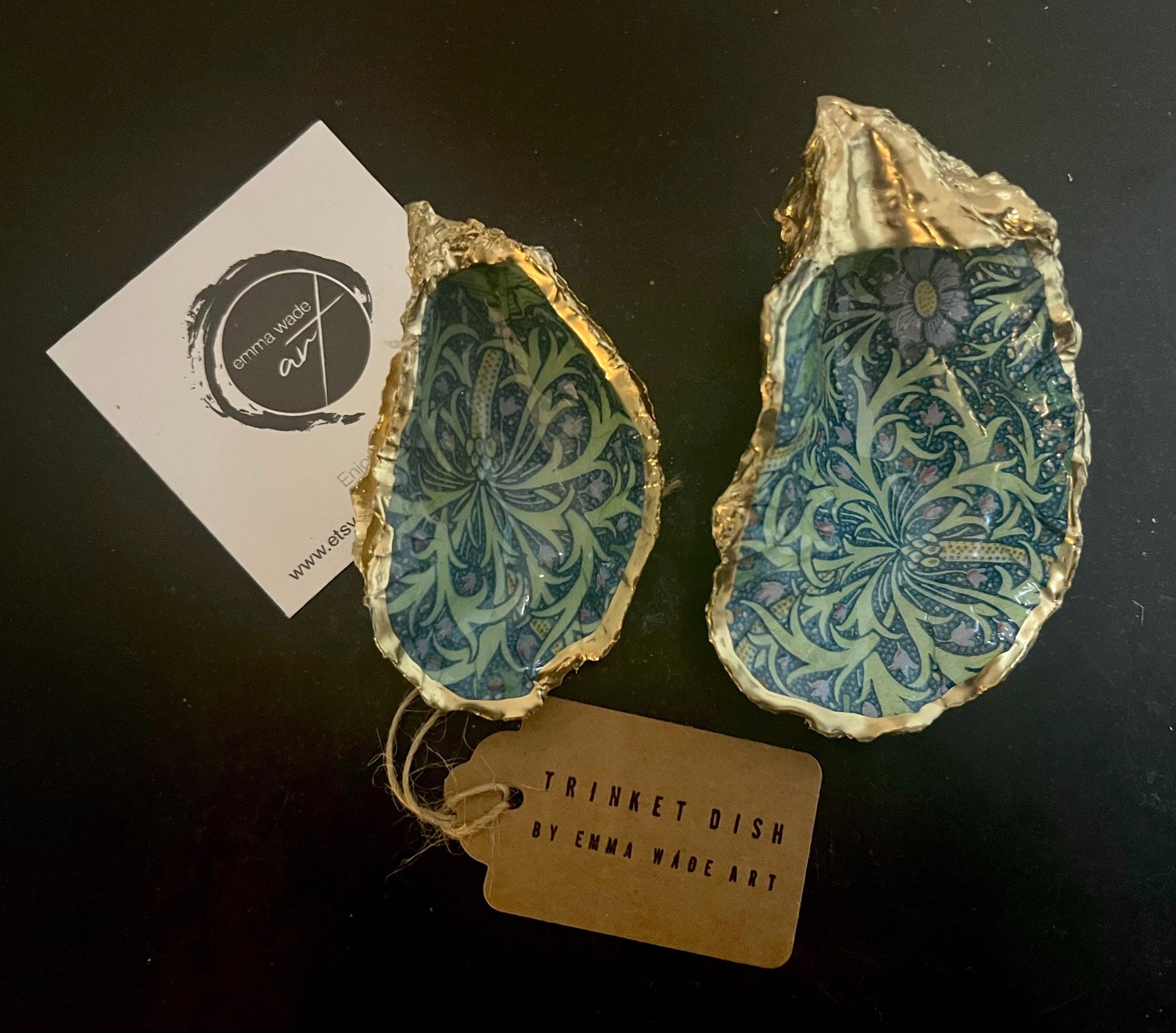 Handmade William Morris inspired oyster shell trinket dish in green and blue tones, finished with gold leaf and sealed with glossy resin. Coastal jewellery dish made from a Dorset oyster shell, featuring a seaweed decoupage design. Perfect for holding rings, earrings and small treasures. Decorative shell bowl photographed on a light background, showing the natural shell shape, detailed pattern and gilded edges.