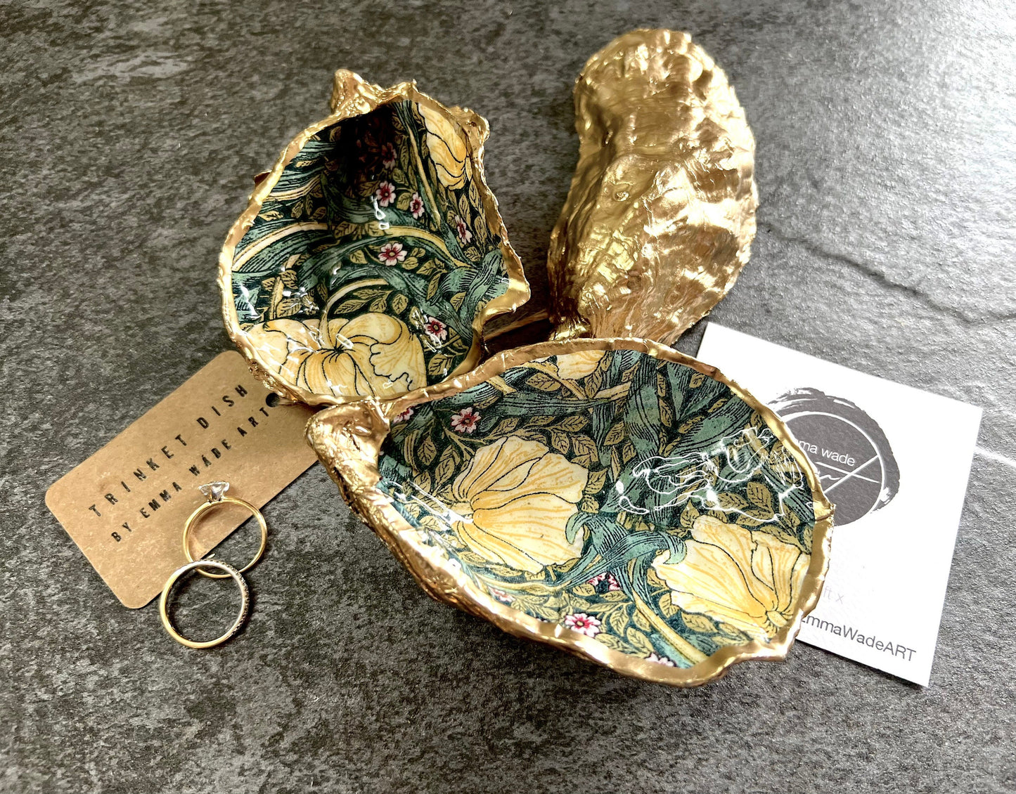 William Morris Golden Green Pimpernel oyster shell ring dish with gold leaf edge. A unique shell ring holder, ring tray, and jewellery organiser for rings, earrings, or cufflinks. Each shell features an art inspired floral design and is individually handmade from Dorset shells. Perfect as a trinket dish for bedside or dressing table storage. A thoughtful gift for weddings, anniversaries, birthdays, bridesmaids, or Christmas. A sustainable decorative keepsake for any jewellery lover.