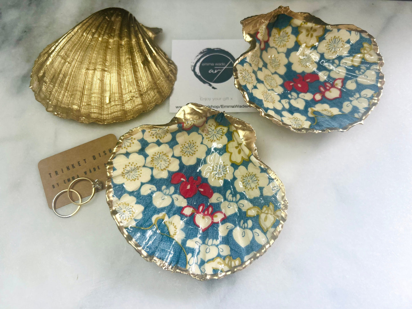 Japanese Sakura cherry blossom floral scallop shell trinket dish with blue, cream and red botanical flower design, hand finished with liquid gold leaf edging and glossy resin. Handmade coastal jewellery tray and ring dish inspired by Japanese floral art and Dorset coastal décor.