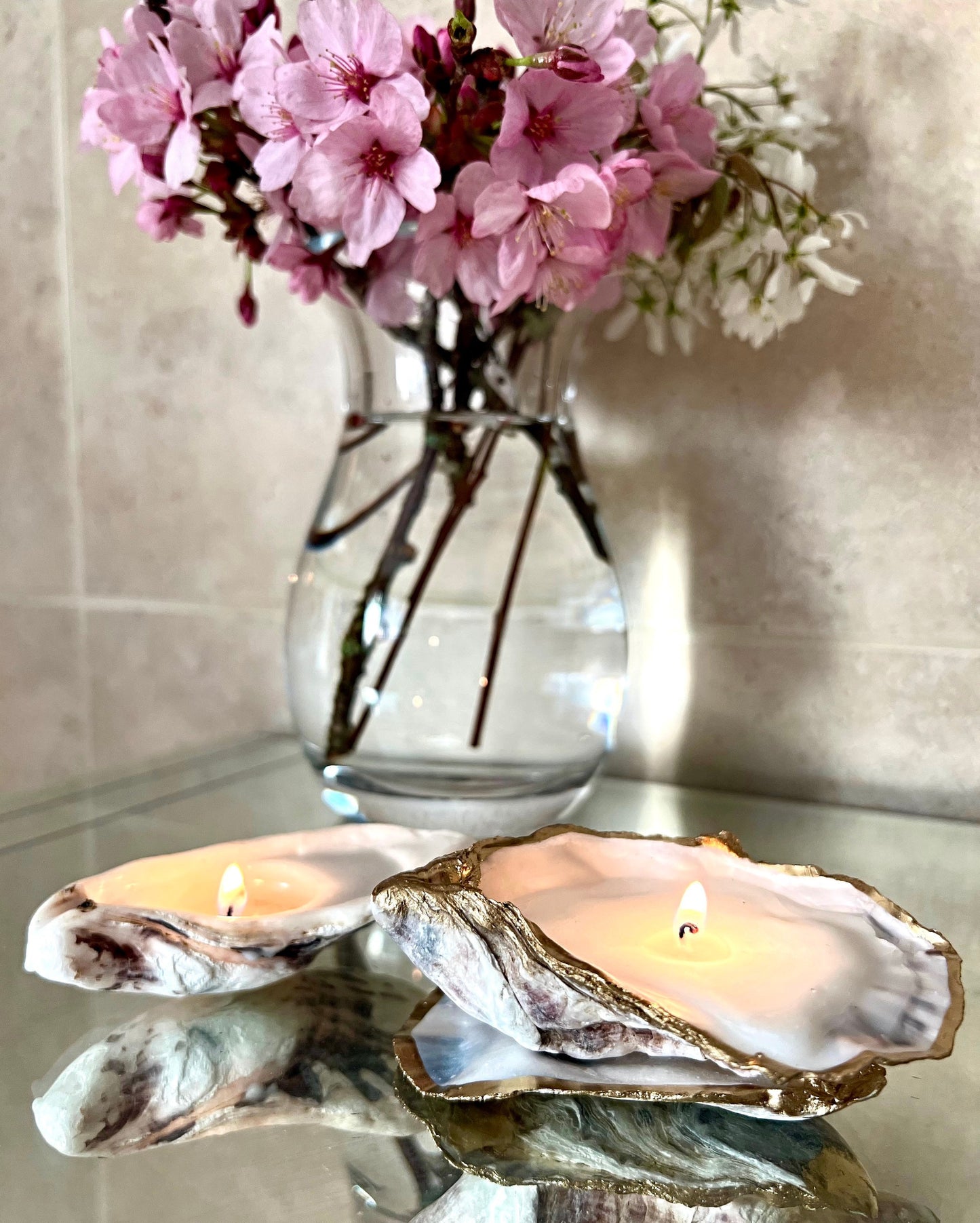 Luxury oyster shell candle hand poured with natural vegetable wax inside a real Dorset oyster shell with gold leaf edging. Coastal candle decor with polished pearl shell interior and artisan handmade styling. Sustainable shell candle gift for weddings, birthdays, spa decor and coastal home interiors.