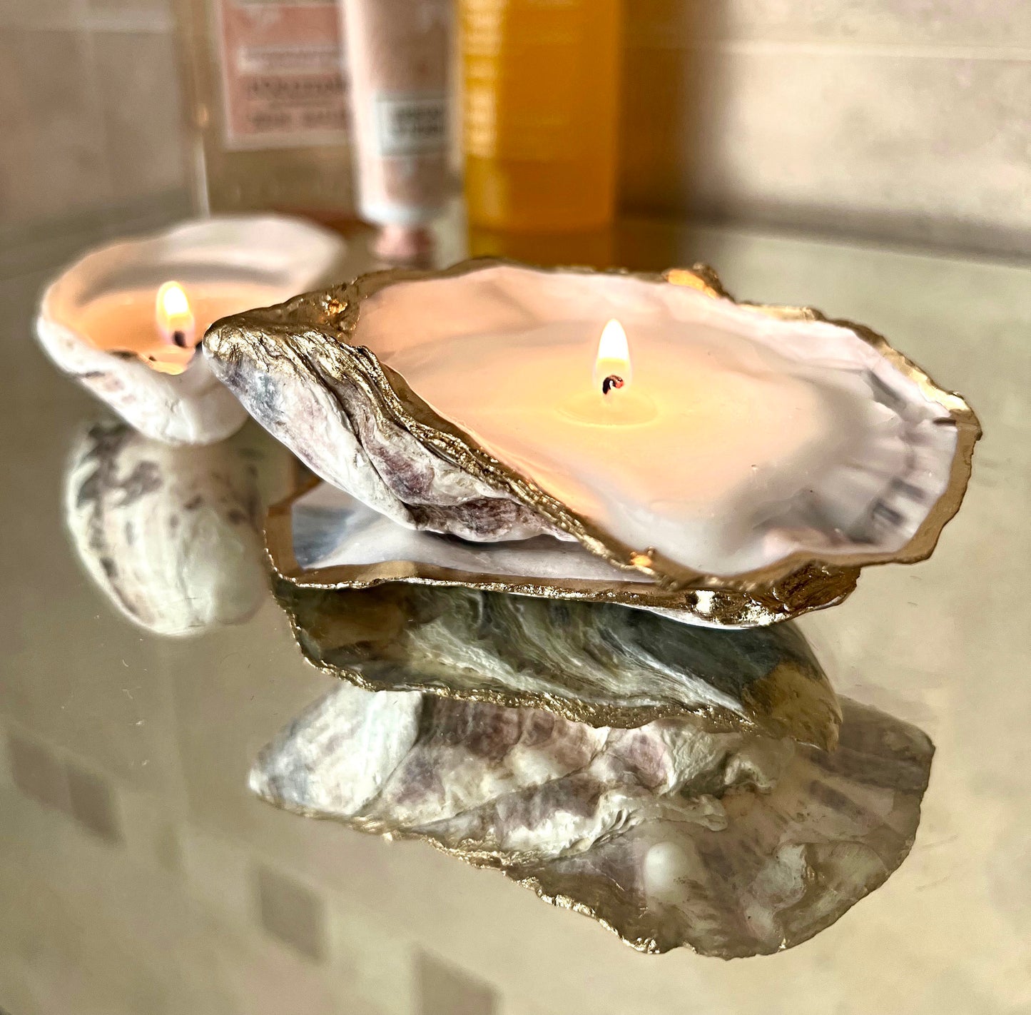 Luxury oyster shell candle hand poured with natural vegetable wax inside a real Dorset oyster shell with gold leaf edging. Coastal candle decor with polished pearl shell interior and artisan handmade styling. Sustainable shell candle gift for weddings, birthdays, spa decor and coastal home interiors.