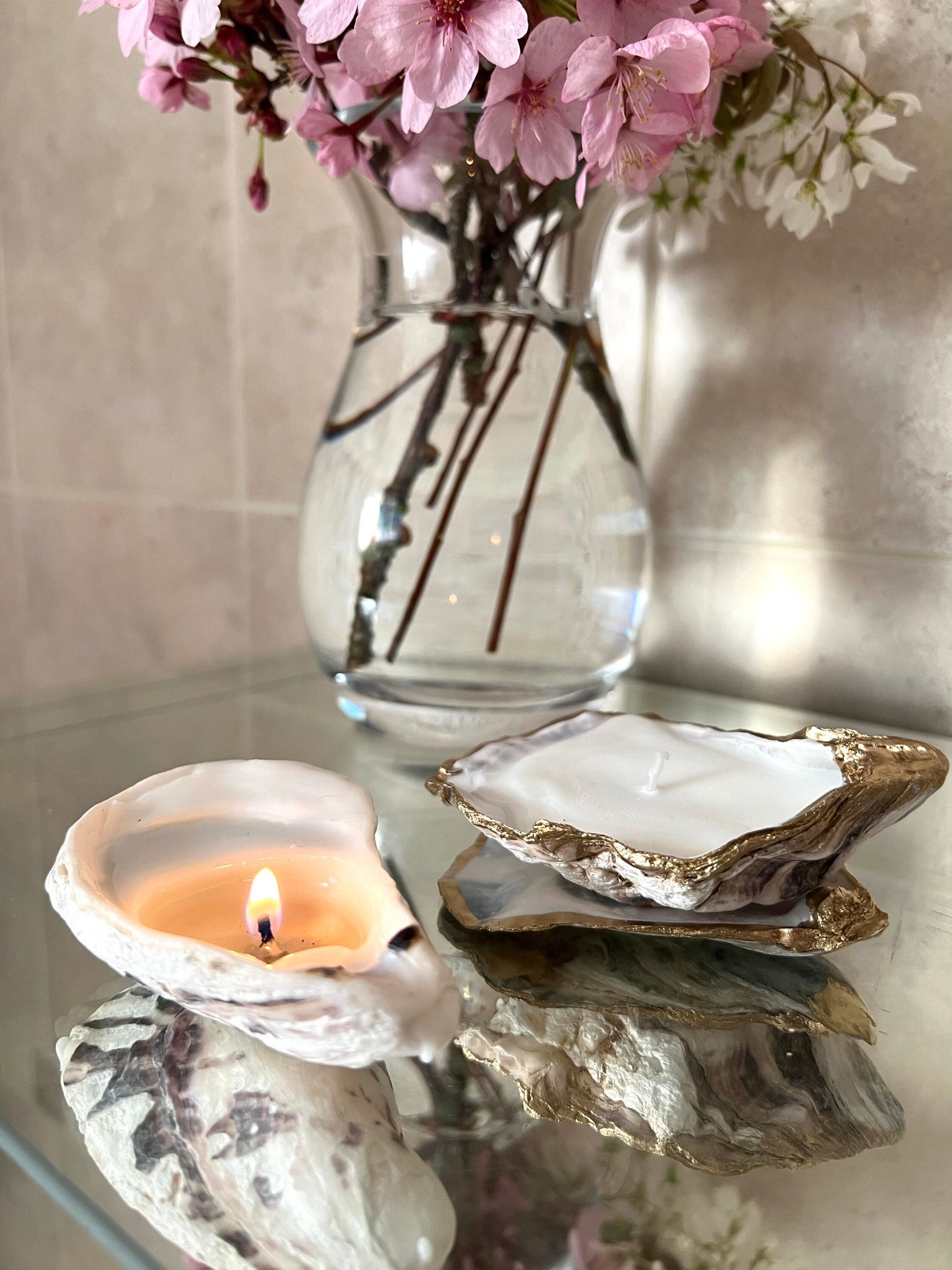 Luxury oyster shell candle hand poured with natural vegetable wax inside a real Dorset oyster shell with gold leaf edging. Coastal candle decor with polished pearl shell interior and artisan handmade styling. Sustainable shell candle gift for weddings, birthdays, spa decor and coastal home interiors.
