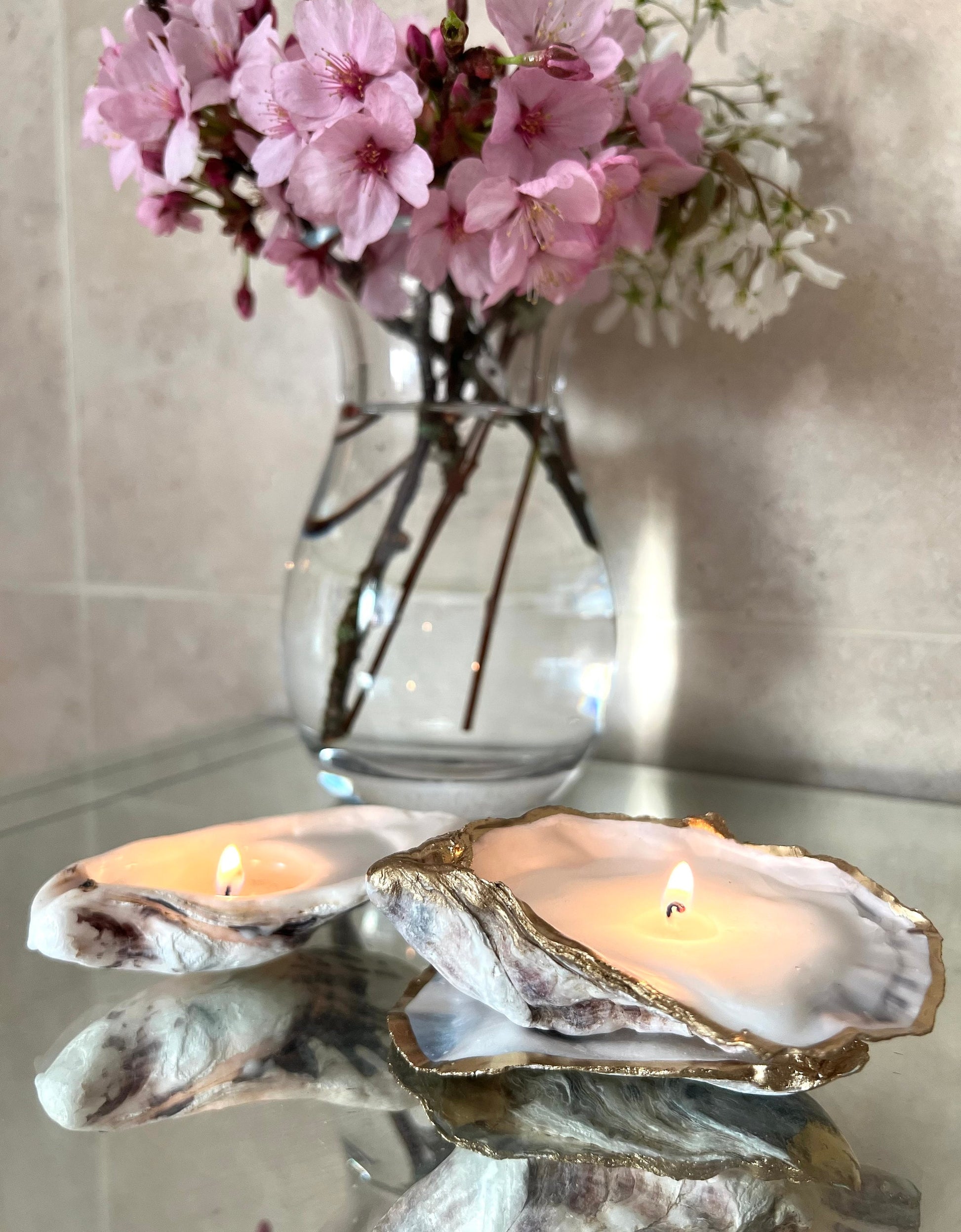 Luxury oyster shell candle hand poured with natural vegetable wax inside a real Dorset oyster shell with gold leaf edging. Coastal candle decor with polished pearl shell interior and artisan handmade styling. Sustainable shell candle gift for weddings, birthdays, spa decor and coastal home interiors.