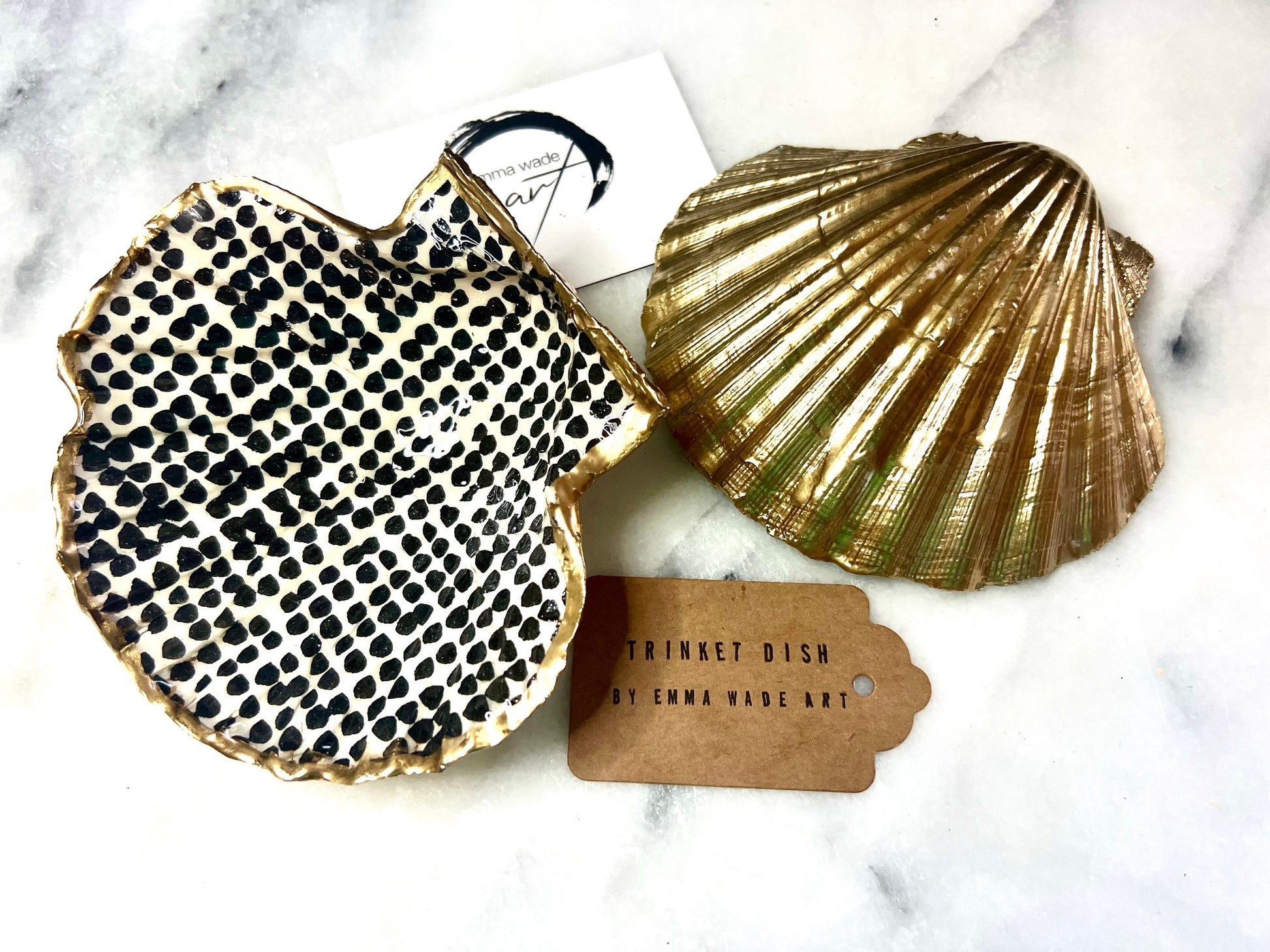 Handcrafted black and white dotted Dorset scallop shell trinket dish, gilded with real gold leaf and sealed in crystal-clear resin. Perfect as a jewellery holder, cufflink tray, tea light holder, or coastal home accent. Each eco-friendly shell is ethically sourced from the Dorset coastline, individually hand finished in Surrey, and presented in a sustainable gift box. A thoughtful handmade gift for ocean lovers, weddings, birthdays, or coastal home décor.