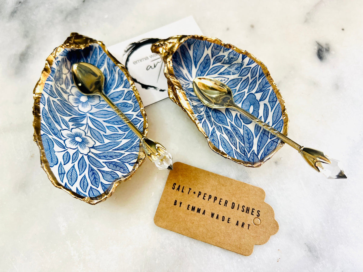 Sustainable Dorset oyster shell cruet set featuring blue floral designs and real gold leaf edges | Handmade salt and pepper pinch pots, sealed with food-safe glossy resin and presented in a sustainable kraft gift box | A unique salt gift for weddings, anniversaries, and coastal dining | Includes optional gold crystal spoons | Perfect handmade gift for beach house decor or ocean-inspired table styling | Maimekko Design