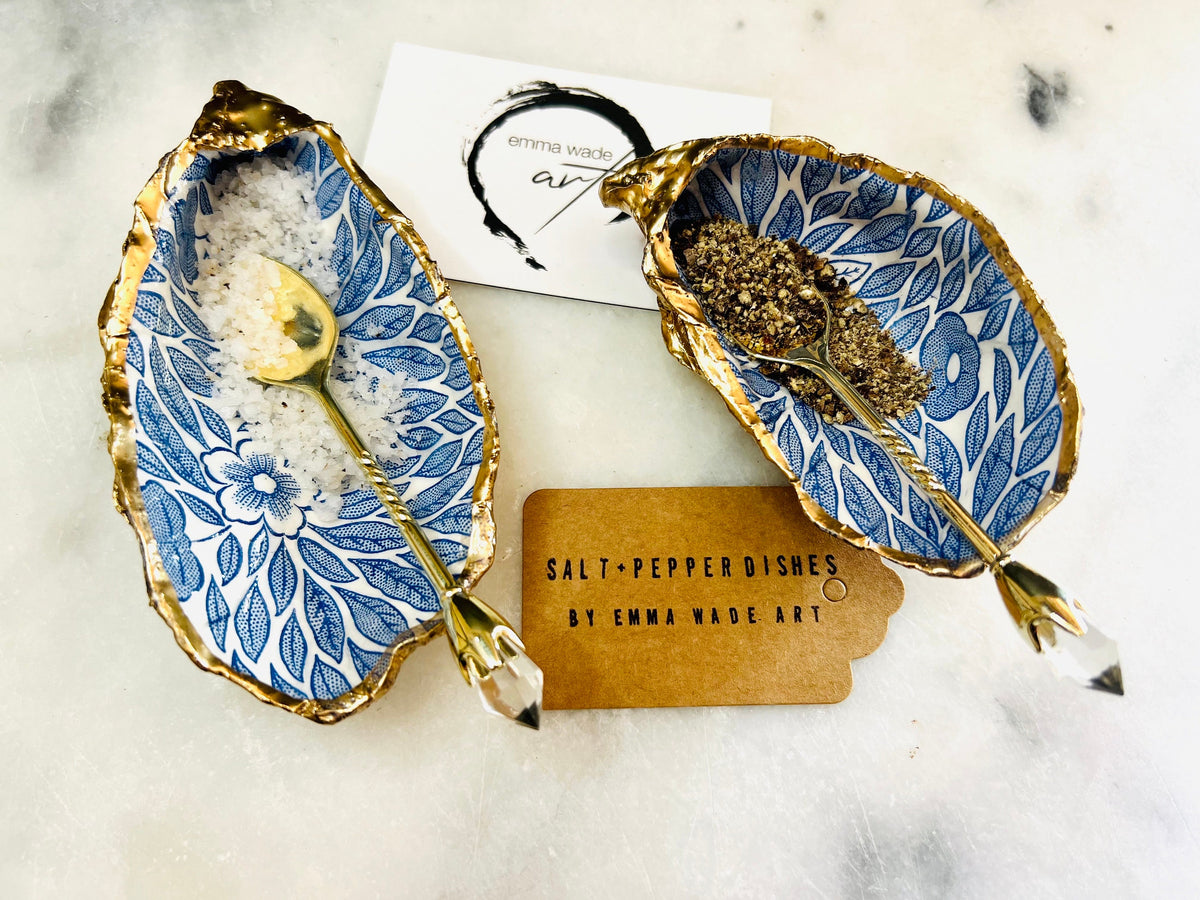 Sustainable Dorset oyster shell cruet set featuring blue floral designs and real gold leaf edges | Handmade salt and pepper pinch pots, sealed with food-safe glossy resin and presented in a sustainable kraft gift box | A unique salt gift for weddings, anniversaries, and coastal dining | Includes optional gold crystal spoons | Perfect handmade gift for beach house decor or ocean-inspired table styling | Maimekko Design