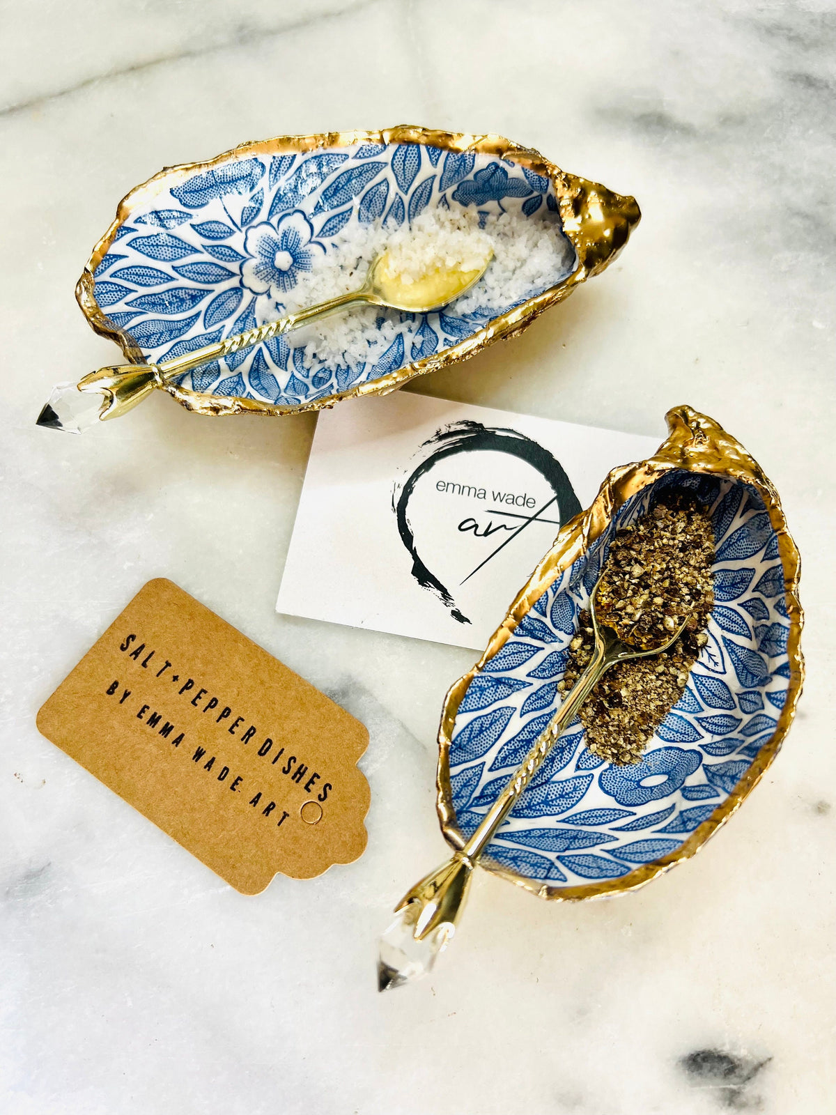 Sustainable Dorset oyster shell cruet set featuring blue floral designs and real gold leaf edges | Handmade salt and pepper pinch pots, sealed with food-safe glossy resin and presented in a sustainable kraft gift box | A unique salt gift for weddings, anniversaries, and coastal dining | Includes optional gold crystal spoons | Perfect handmade gift for beach house decor or ocean-inspired table styling | Maimekko Design