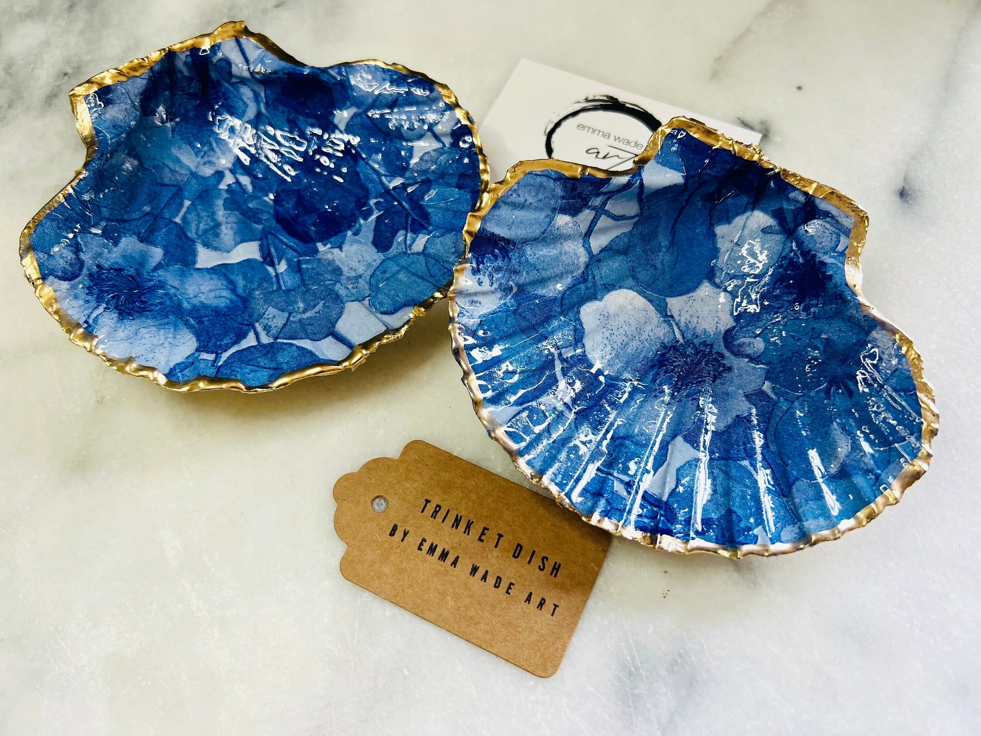 Deep blue watercolour floral scallop shell trinket dish with hand gilded gold leaf edging and glossy resin finish. Handmade Dorset shell jewellery holder in rich cobalt and ocean blue tones, styled as coastal home décor with pearls and gold details.