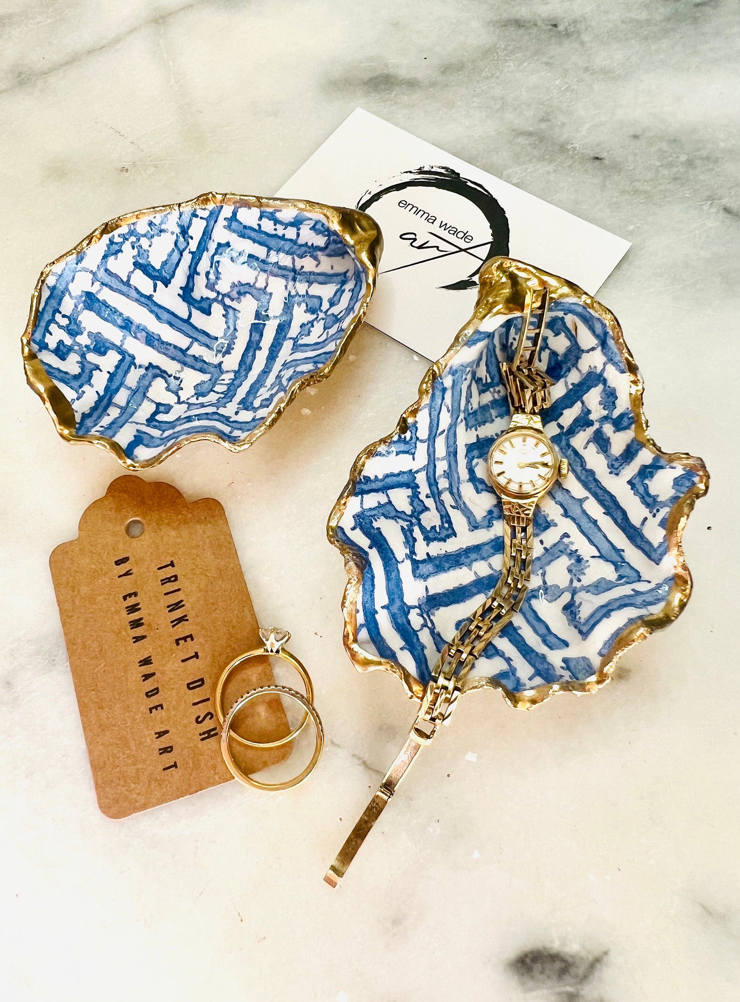 Handmade blue fretwork oyster shell trinket dish shown as a single piece, crafted from a natural Dorset oyster shell and finished with genuine gold leaf edges and glossy resin. Featuring an intricate blue fretwork pattern, this jewellery and ring holder is perfect for a bedside table, bathroom or coastal-inspired decor. Each shell is one of a kind and carefully finished by hand.