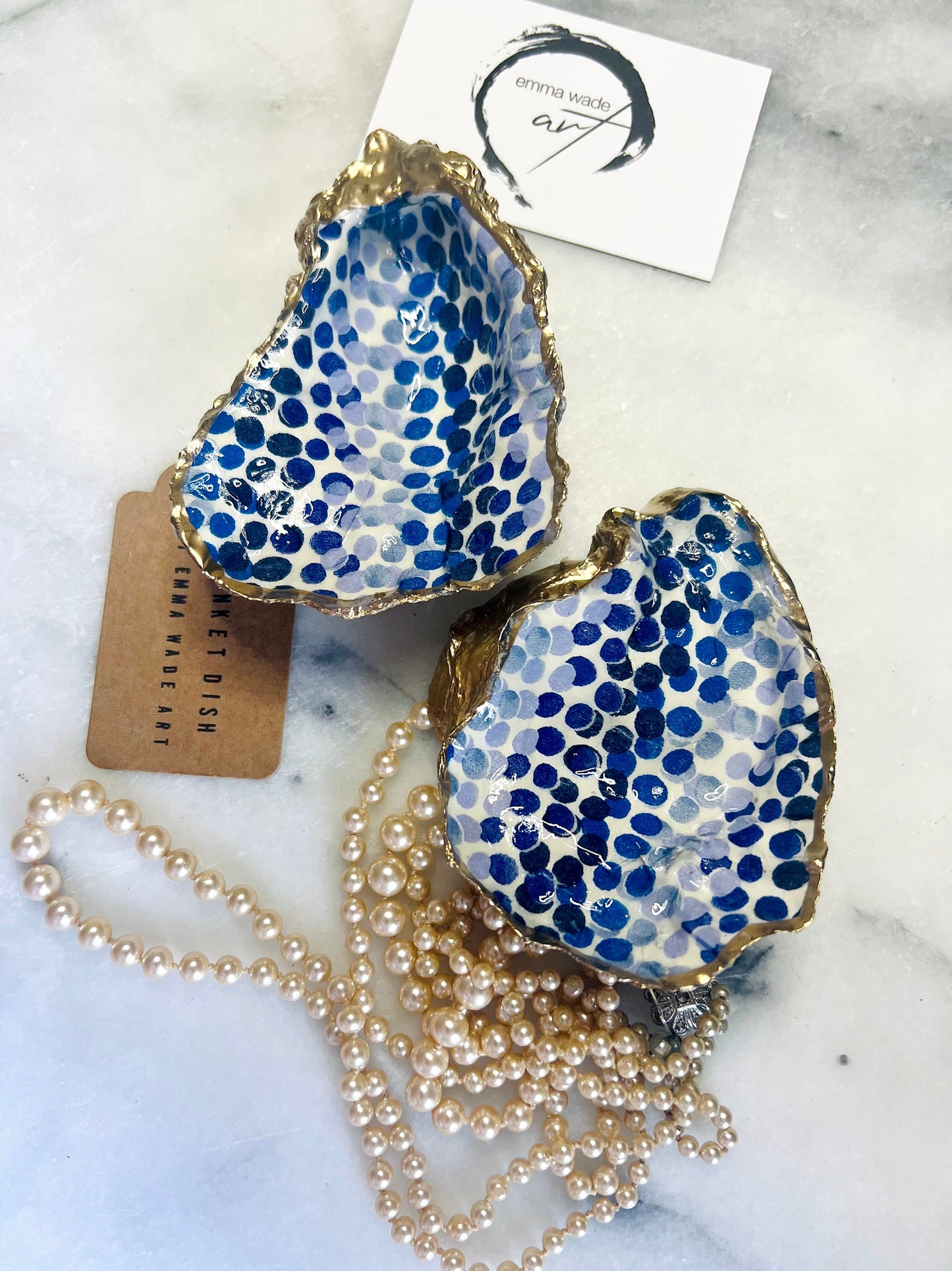 Handmade Emma Bridgewater Blue Dots oyster shell trinket dish, shown as a single jewellery tray with a blue and white dot pattern and hand-gilded gold leaf edges. Crafted from a natural Dorset oyster shell and sealed with glossy, crystal-clear resin. Coastal-inspired home decor, perfect for holding rings, earrings and small keepsakes, with each shell one of a kind and finished by hand.