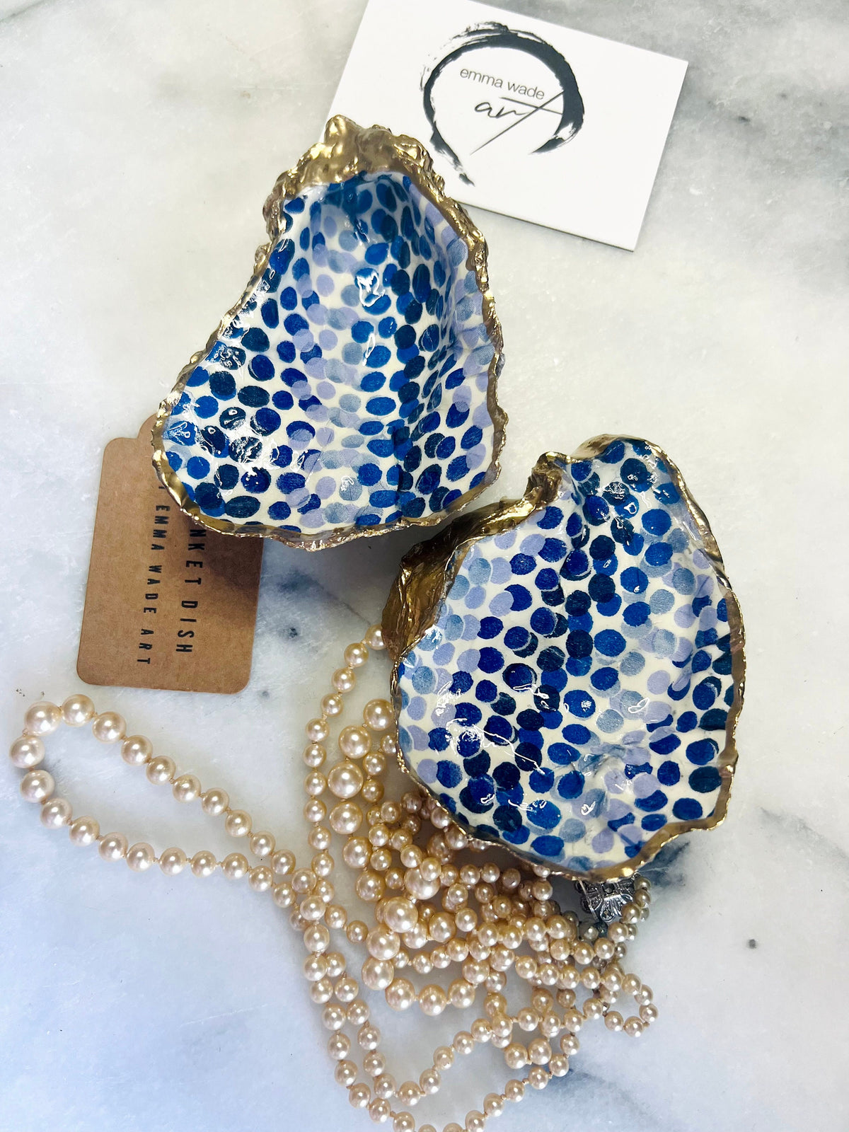 Handmade Emma Bridgewater Blue Dots oyster shell trinket dish, shown as a single jewellery tray with a blue and white dot pattern and hand-gilded gold leaf edges. Crafted from a natural Dorset oyster shell and sealed with glossy, crystal-clear resin. Coastal-inspired home decor, perfect for holding rings, earrings and small keepsakes, with each shell one of a kind and finished by hand.