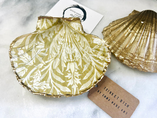 Handmade scallop shell trinket dishes featuring a William Morris gold and ivory acorn heritage pattern with shimmering liquid gold leaf edging. Natural Dorset scallop shells sealed in glossy crystal clear resin and styled as luxury jewellery holders, vanity trays and coastal home décor accessories. Elegant Arts and Crafts inspired shell dishes photographed on a marble background with pearls and decorative styling.