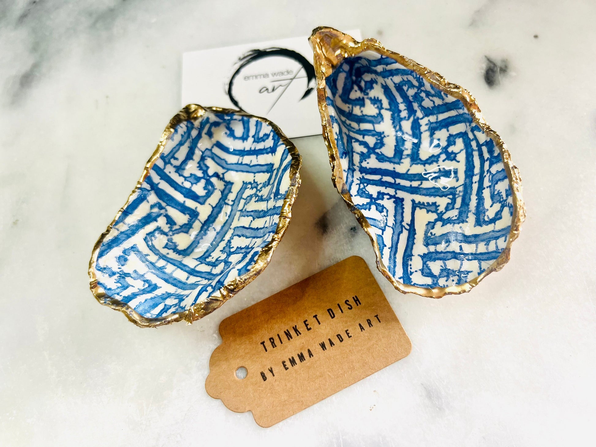 Handmade blue fretwork oyster shell trinket dish shown as a single piece, crafted from a natural Dorset oyster shell and finished with genuine gold leaf edges and glossy resin. Featuring an intricate blue fretwork pattern, this jewellery and ring holder is perfect for a bedside table, bathroom or coastal-inspired decor. Each shell is one of a kind and carefully finished by hand.