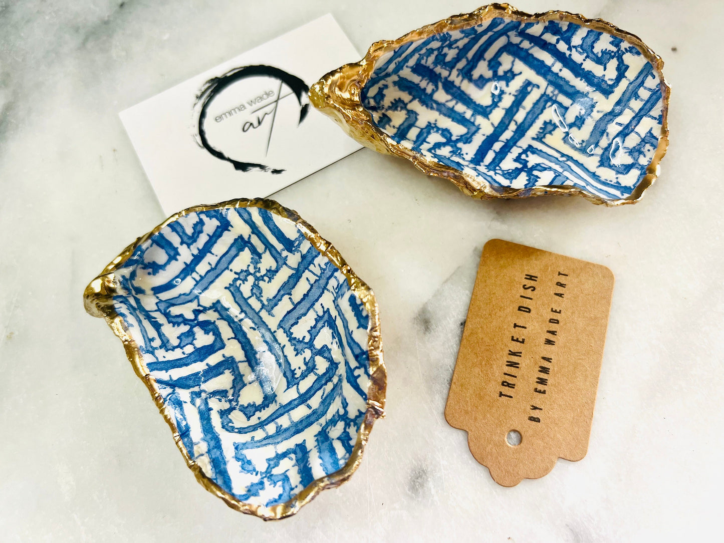 Handmade blue fretwork oyster shell trinket dish shown as a single piece, crafted from a natural Dorset oyster shell and finished with genuine gold leaf edges and glossy resin. Featuring an intricate blue fretwork pattern, this jewellery and ring holder is perfect for a bedside table, bathroom or coastal-inspired decor. Each shell is one of a kind and carefully finished by hand.