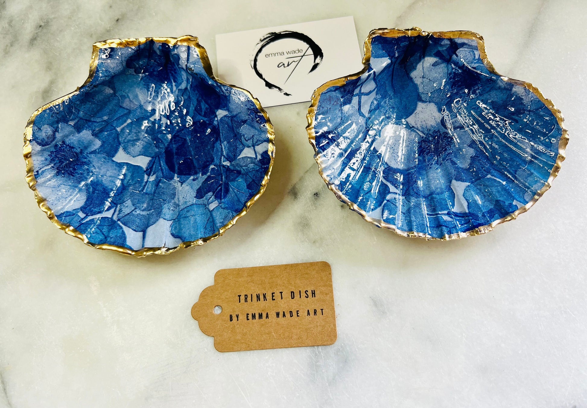 Deep blue watercolour floral scallop shell trinket dish with hand gilded gold leaf edging and glossy resin finish. Handmade Dorset shell jewellery holder in rich cobalt and ocean blue tones, styled as coastal home décor with pearls and gold details.