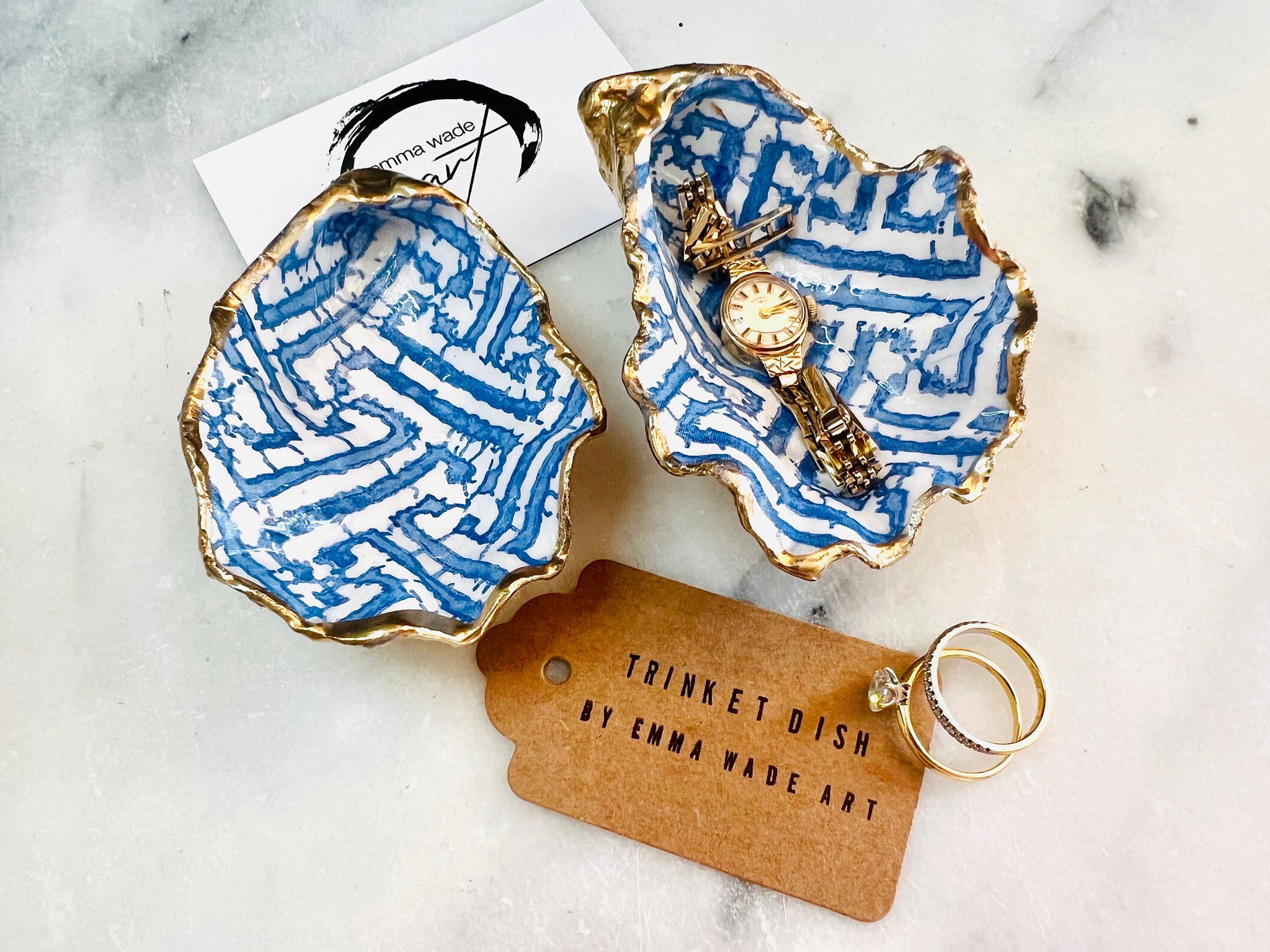 Handmade blue fretwork oyster shell trinket dish shown as a single piece, crafted from a natural Dorset oyster shell and finished with genuine gold leaf edges and glossy resin. Featuring an intricate blue fretwork pattern, this jewellery and ring holder is perfect for a bedside table, bathroom or coastal-inspired decor. Each shell is one of a kind and carefully finished by hand.