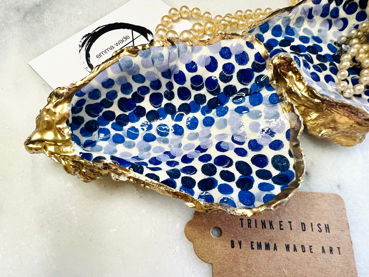 Handmade Emma Bridgewater Blue Dots oyster shell trinket dish, shown as a single jewellery tray with a blue and white dot pattern and hand-gilded gold leaf edges. Crafted from a natural Dorset oyster shell and sealed with glossy, crystal-clear resin. Coastal-inspired home decor, perfect for holding rings, earrings and small keepsakes, with each shell one of a kind and finished by hand.