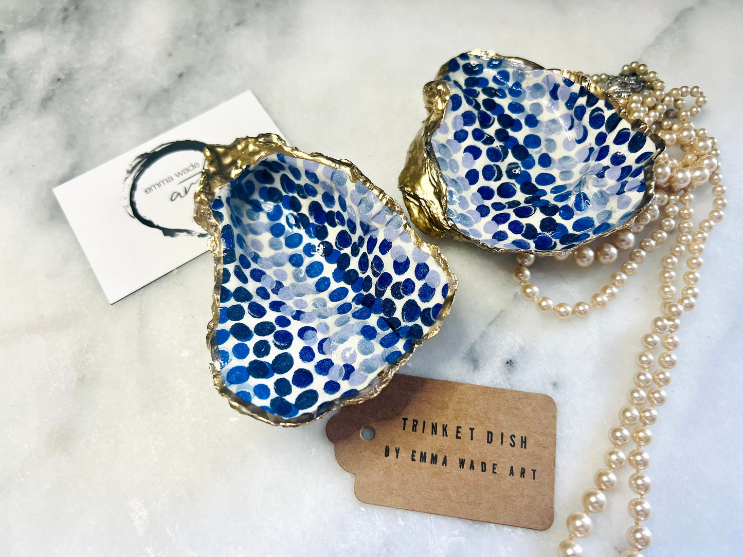 Handmade Emma Bridgewater Blue Dots oyster shell trinket dish, shown as a single jewellery tray with a blue and white dot pattern and hand-gilded gold leaf edges. Crafted from a natural Dorset oyster shell and sealed with glossy, crystal-clear resin. Coastal-inspired home decor, perfect for holding rings, earrings and small keepsakes, with each shell one of a kind and finished by hand.