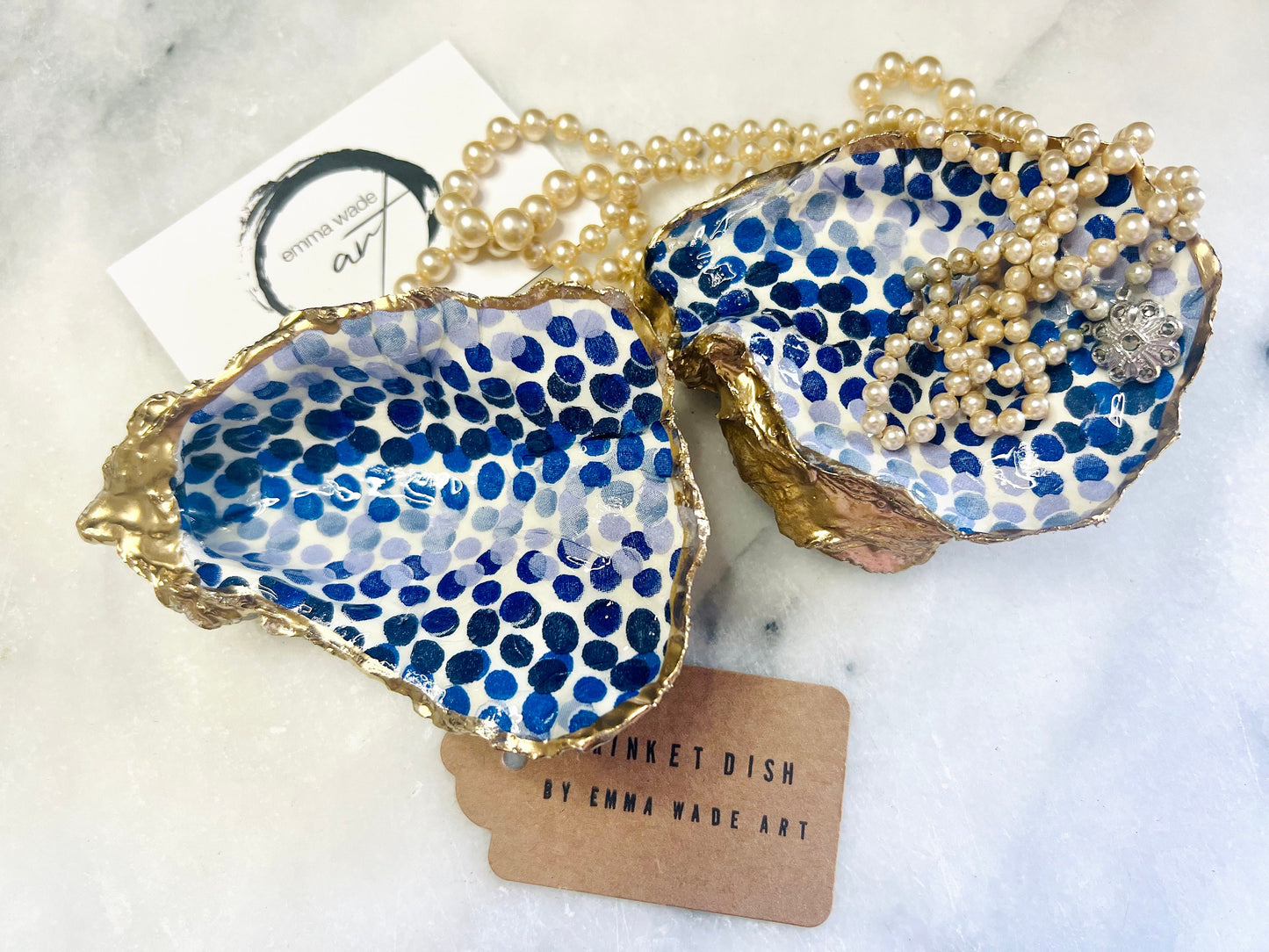 Handmade Emma Bridgewater Blue Dots oyster shell trinket dish, shown as a single jewellery tray with a blue and white dot pattern and hand-gilded gold leaf edges. Crafted from a natural Dorset oyster shell and sealed with glossy, crystal-clear resin. Coastal-inspired home decor, perfect for holding rings, earrings and small keepsakes, with each shell one of a kind and finished by hand.