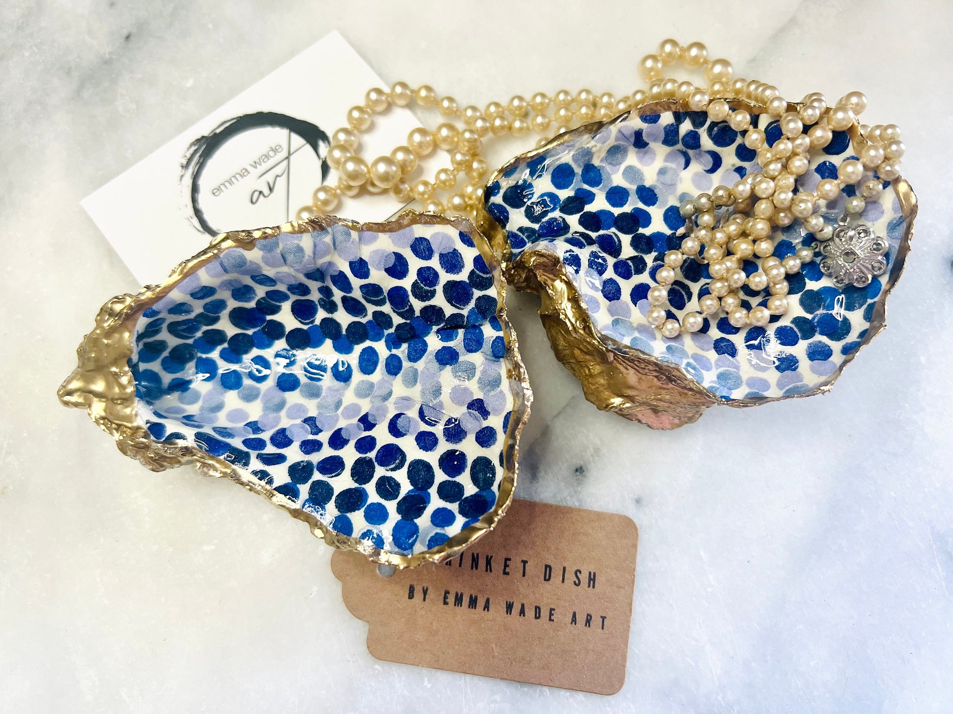 Handmade Emma Bridgewater Blue Dots oyster shell trinket dish, shown as a single jewellery tray with a blue and white dot pattern and hand-gilded gold leaf edges. Crafted from a natural Dorset oyster shell and sealed with glossy, crystal-clear resin. Coastal-inspired home decor, perfect for holding rings, earrings and small keepsakes, with each shell one of a kind and finished by hand.