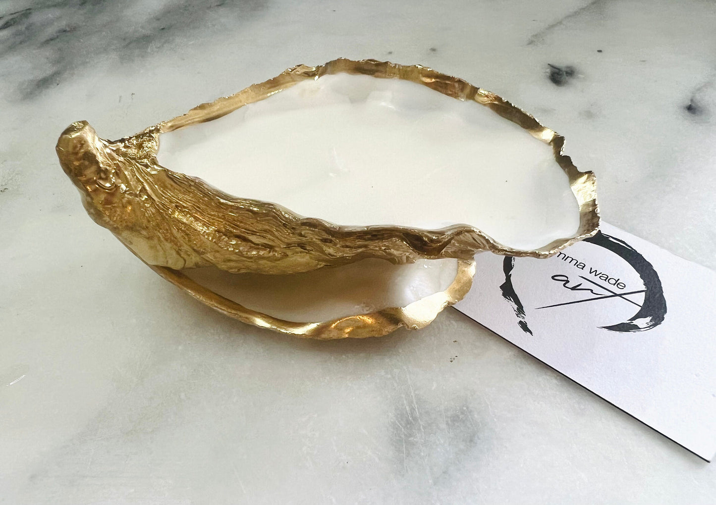 Luxury oyster shell candle hand poured with natural vegetable wax inside a real Dorset oyster shell with gold leaf edging. Coastal candle decor with polished pearl shell interior and artisan handmade styling. Sustainable shell candle gift for weddings, birthdays, spa decor and coastal home interiors.