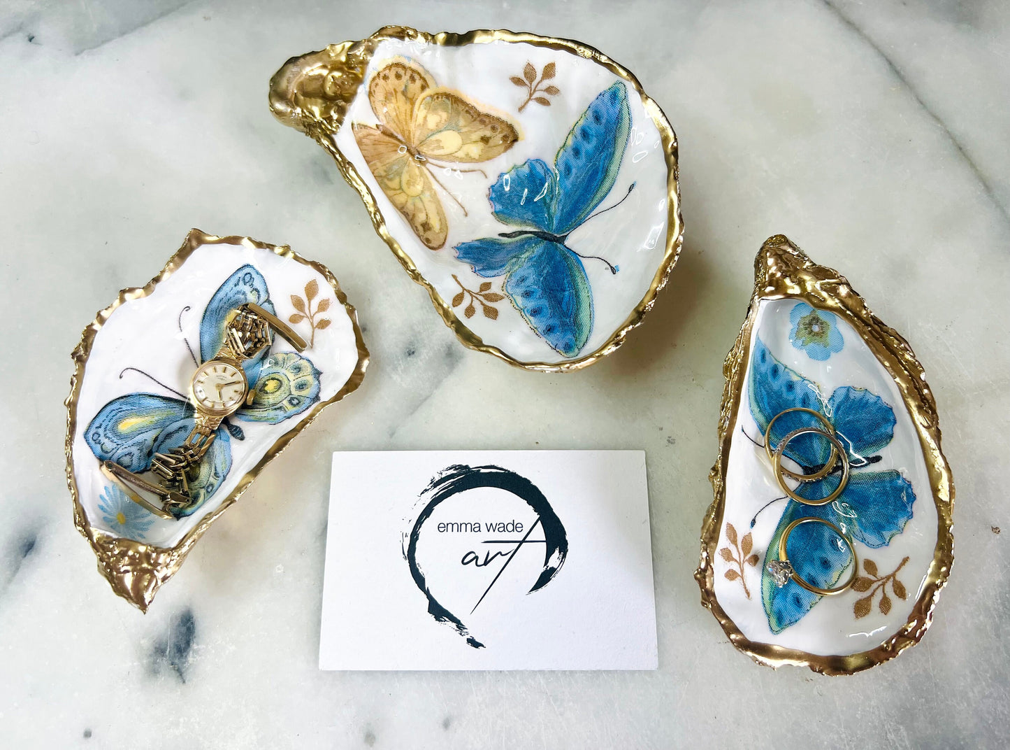 Blue yellow green butterfly oyster shell trinket dish handmade from Dorset coast shell, gold leaf gilded rim and back, high gloss resin interior with colourful butterfly design, coastal home decor jewellery dish, ring holder, trinket tray, seaside gift for her, handmade shell decor, luxury coastal accessory, unique artisan gift UK