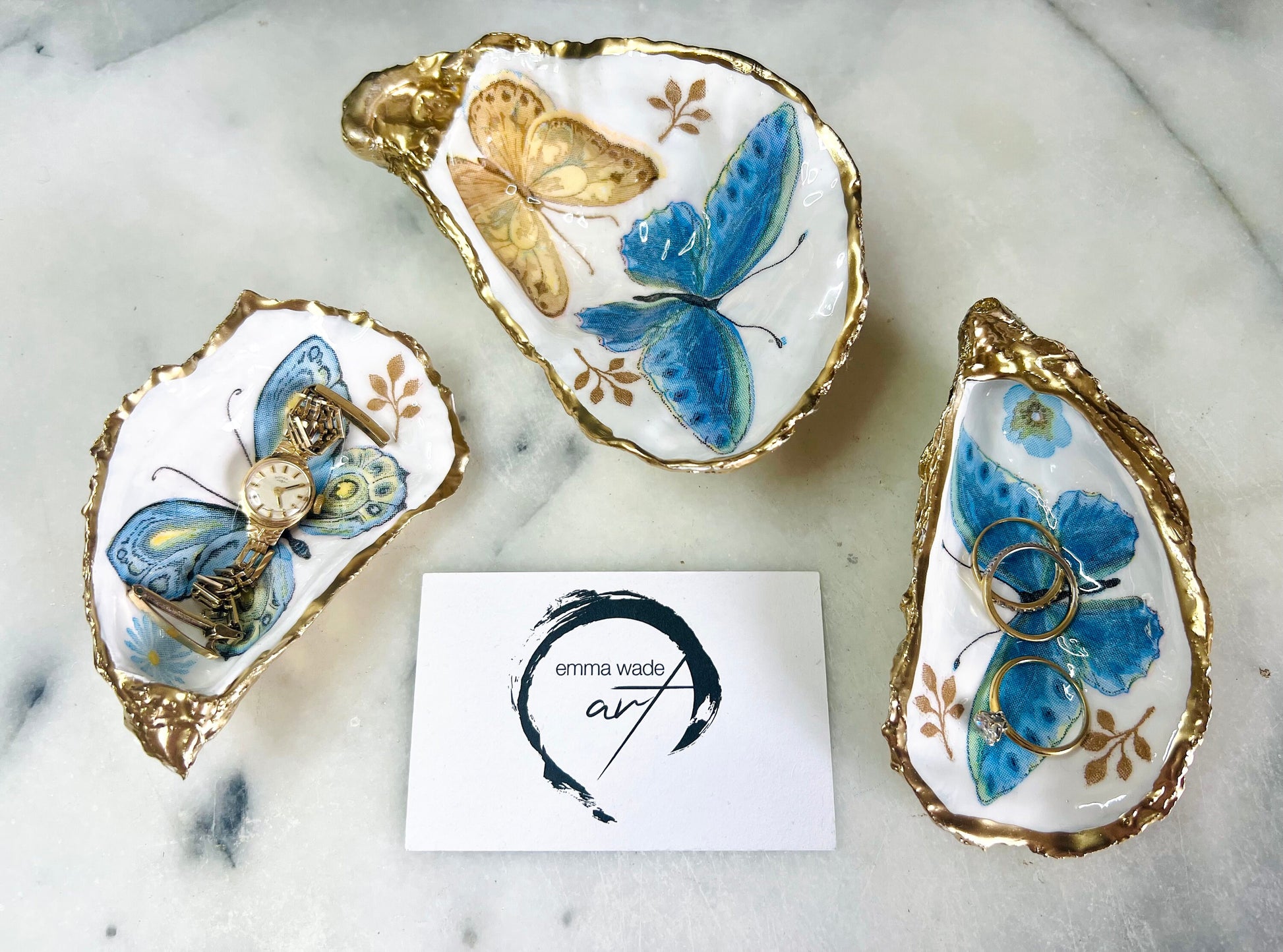 Blue yellow green butterfly oyster shell trinket dish handmade from Dorset coast shell, gold leaf gilded rim and back, high gloss resin interior with colourful butterfly design, coastal home decor jewellery dish, ring holder, trinket tray, seaside gift for her, handmade shell decor, luxury coastal accessory, unique artisan gift UK