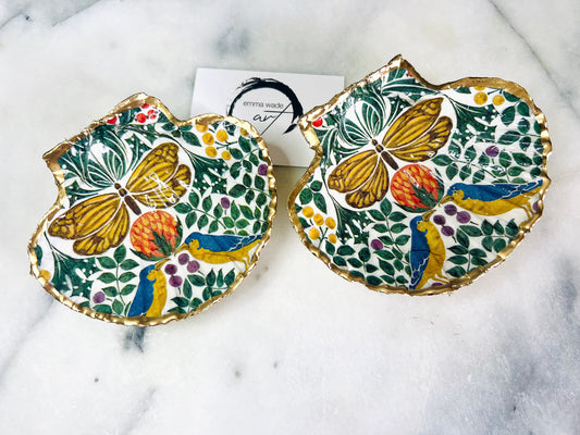 Handmade scallop shell trinket dishes with bird and butterfly design, finished with gold leaf and glossy resin, shown as decorative jewellery trays on a light background, coastal inspired handmade Dorset shell decor.